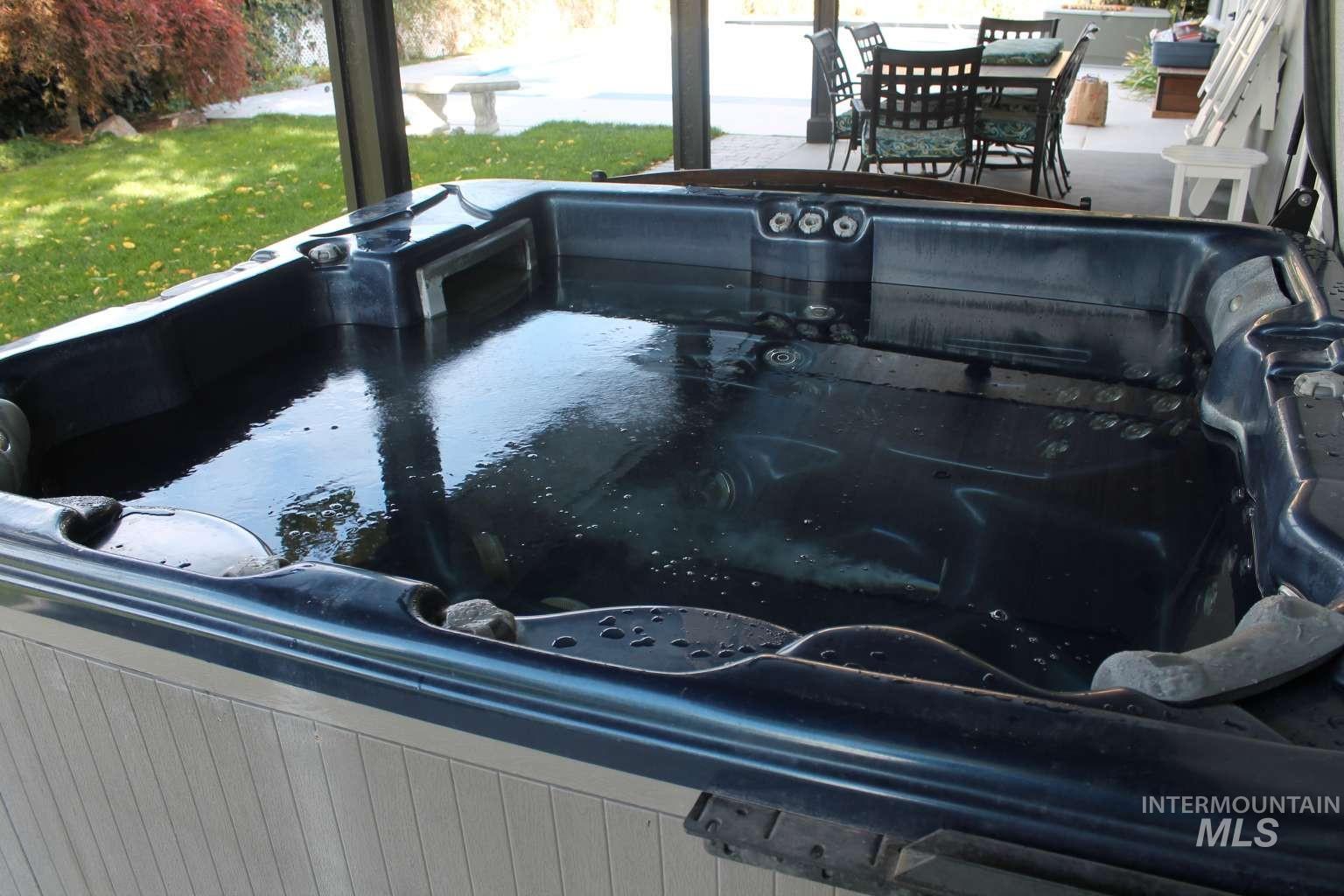 View of pool with a yard and a hot tub
