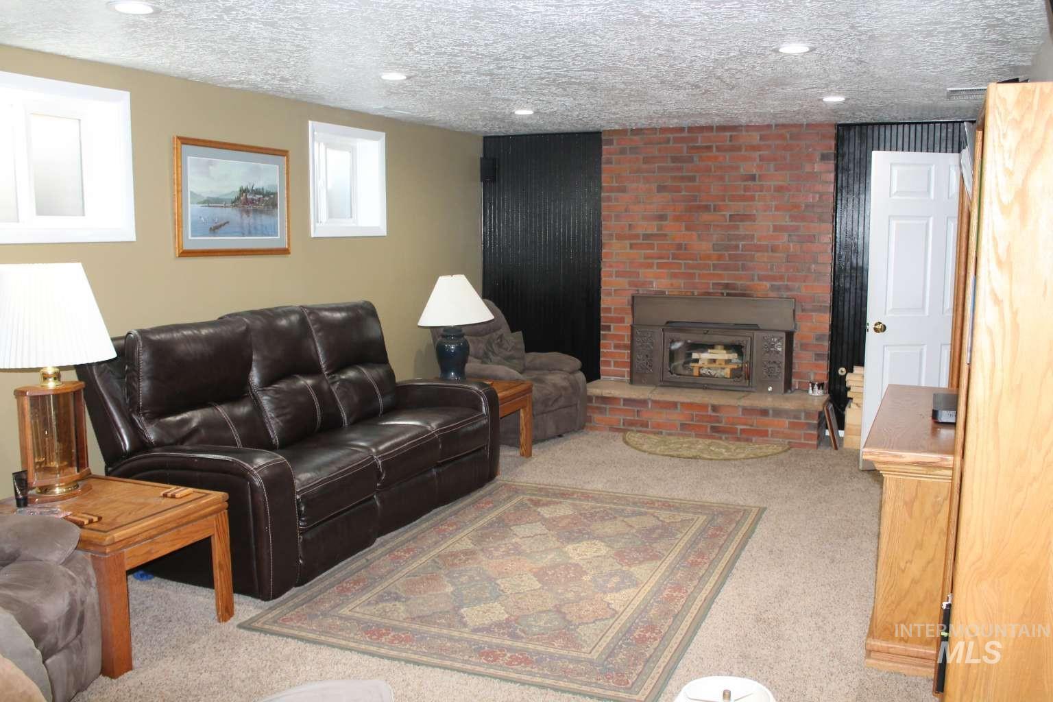 Carpeted living area featuring a textured ceiling, a fireplace, and recessed lighting