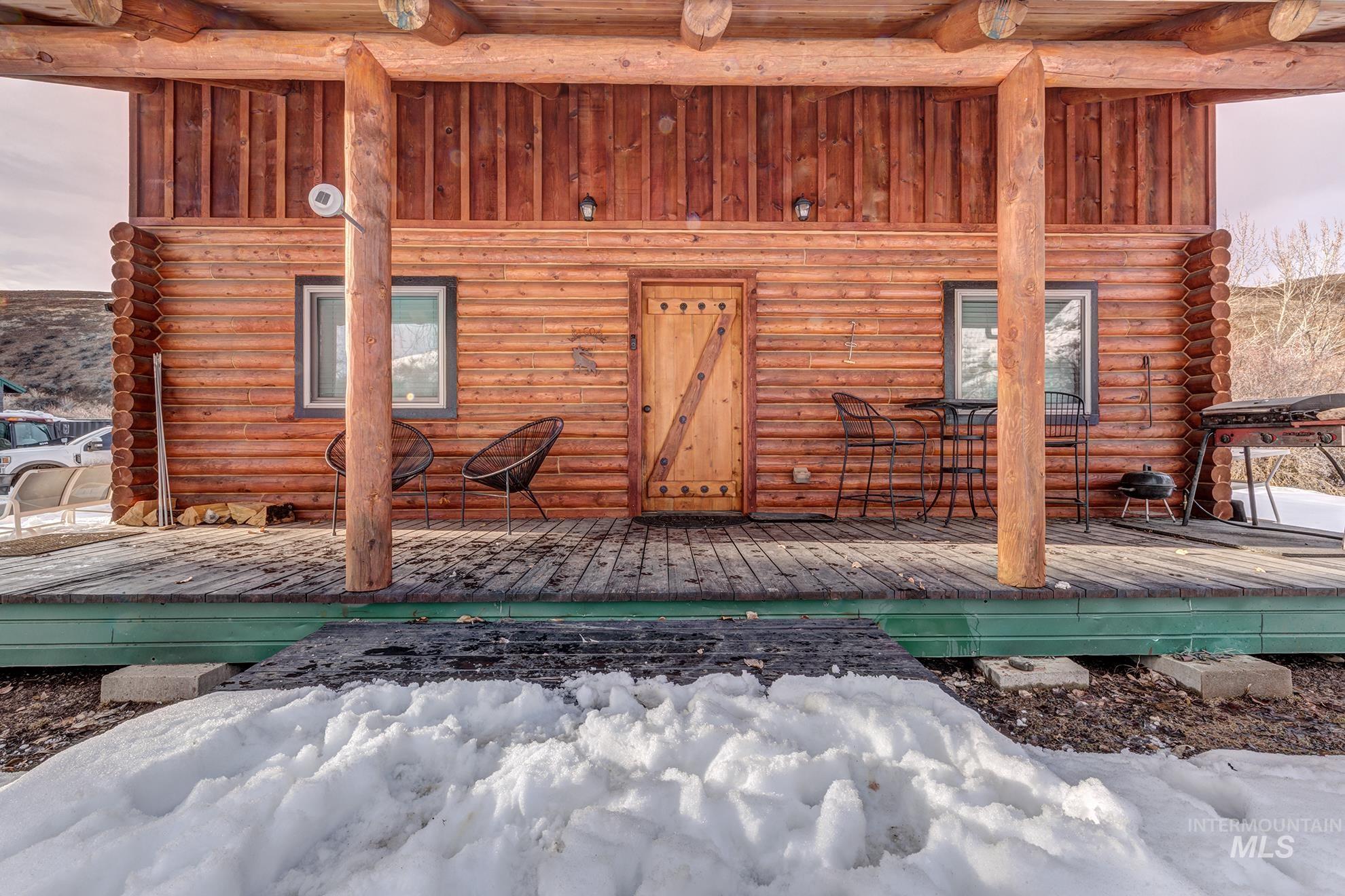 Property entrance with log exterior and a deck