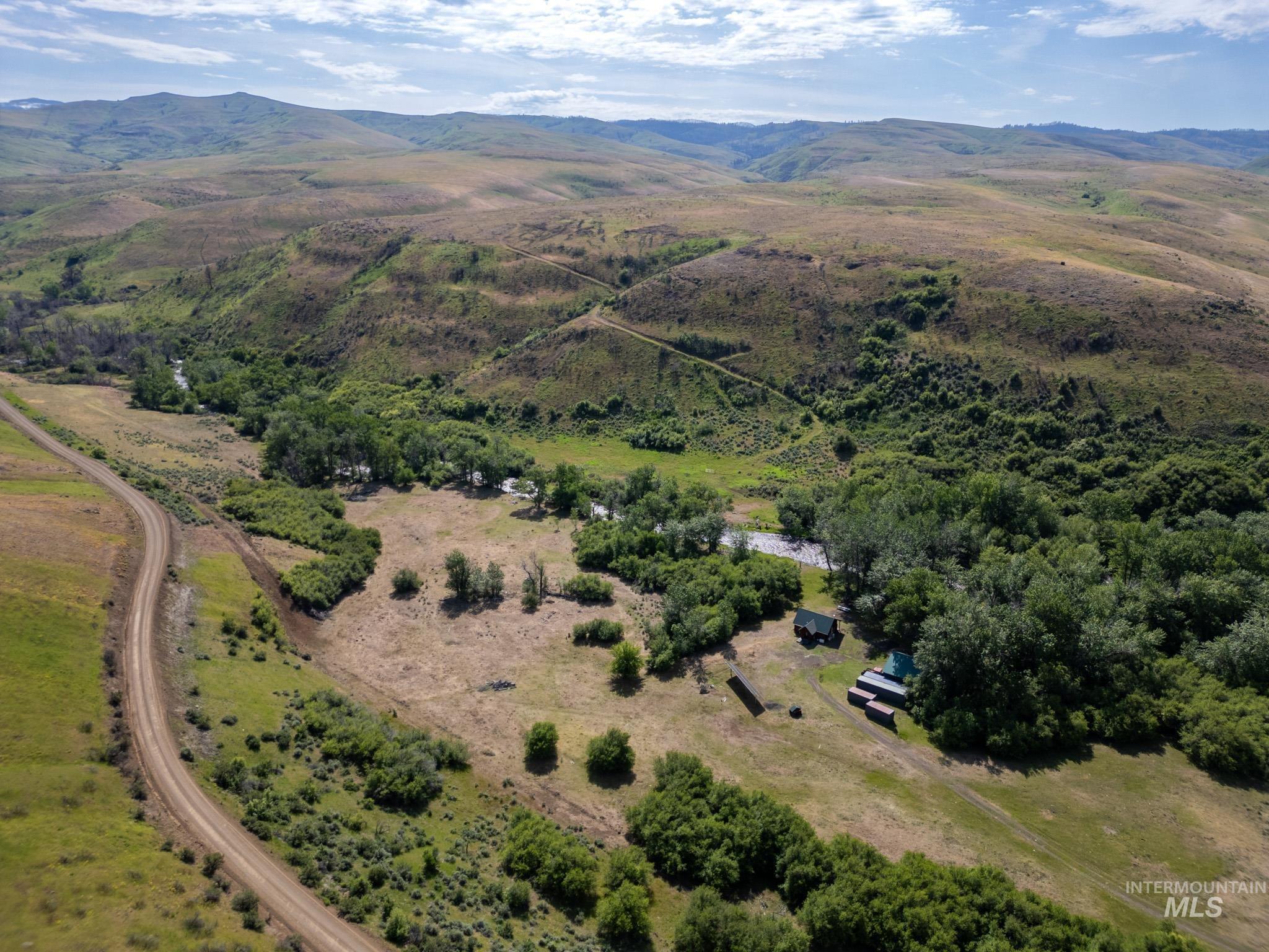 Aerial overview of property's location with a mountain backdrop and rural landscape