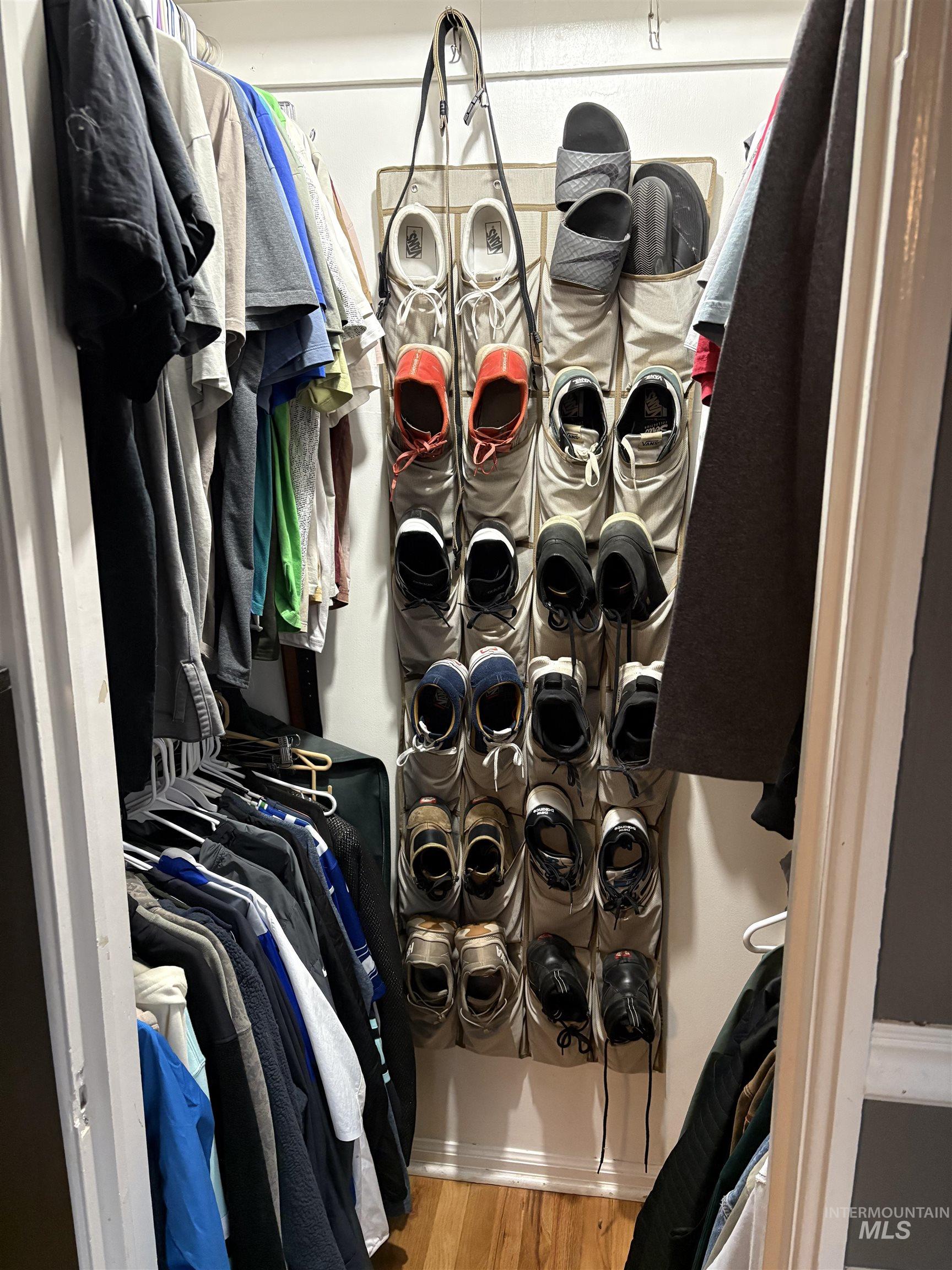 Walk in closet with light wood-style floors