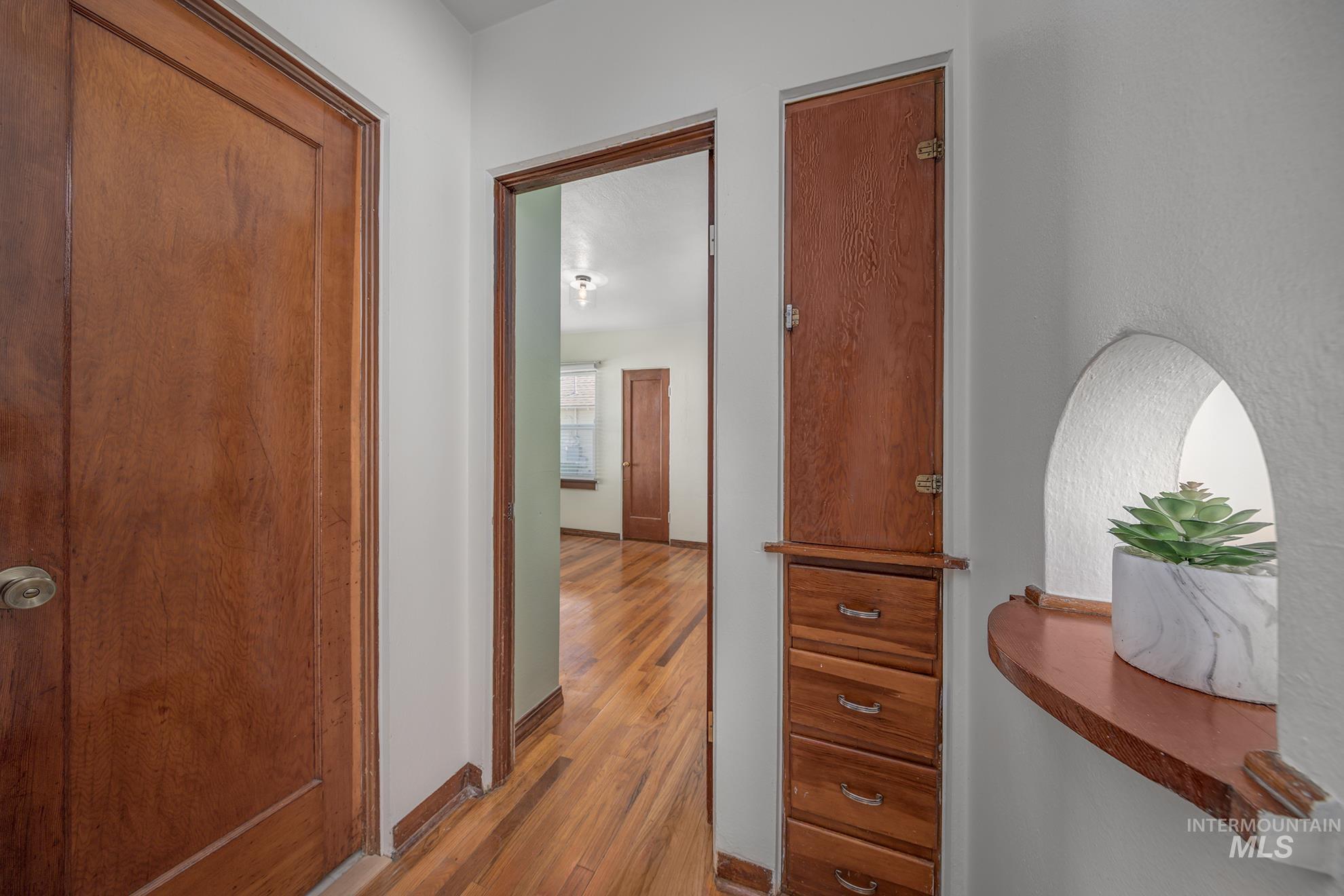 Hallway featuring light wood finished floors and baseboards