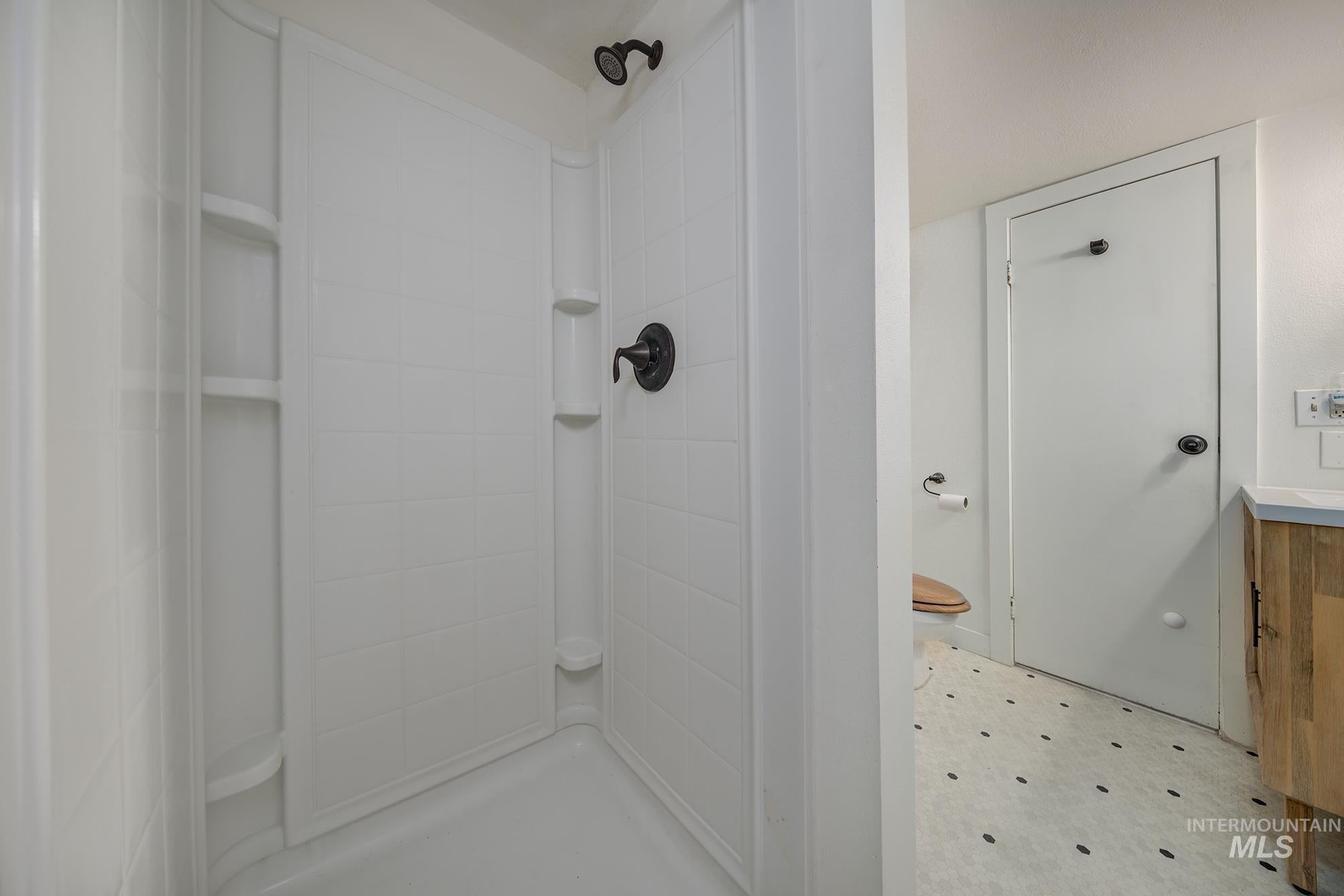 Bathroom with light floors and a stall shower