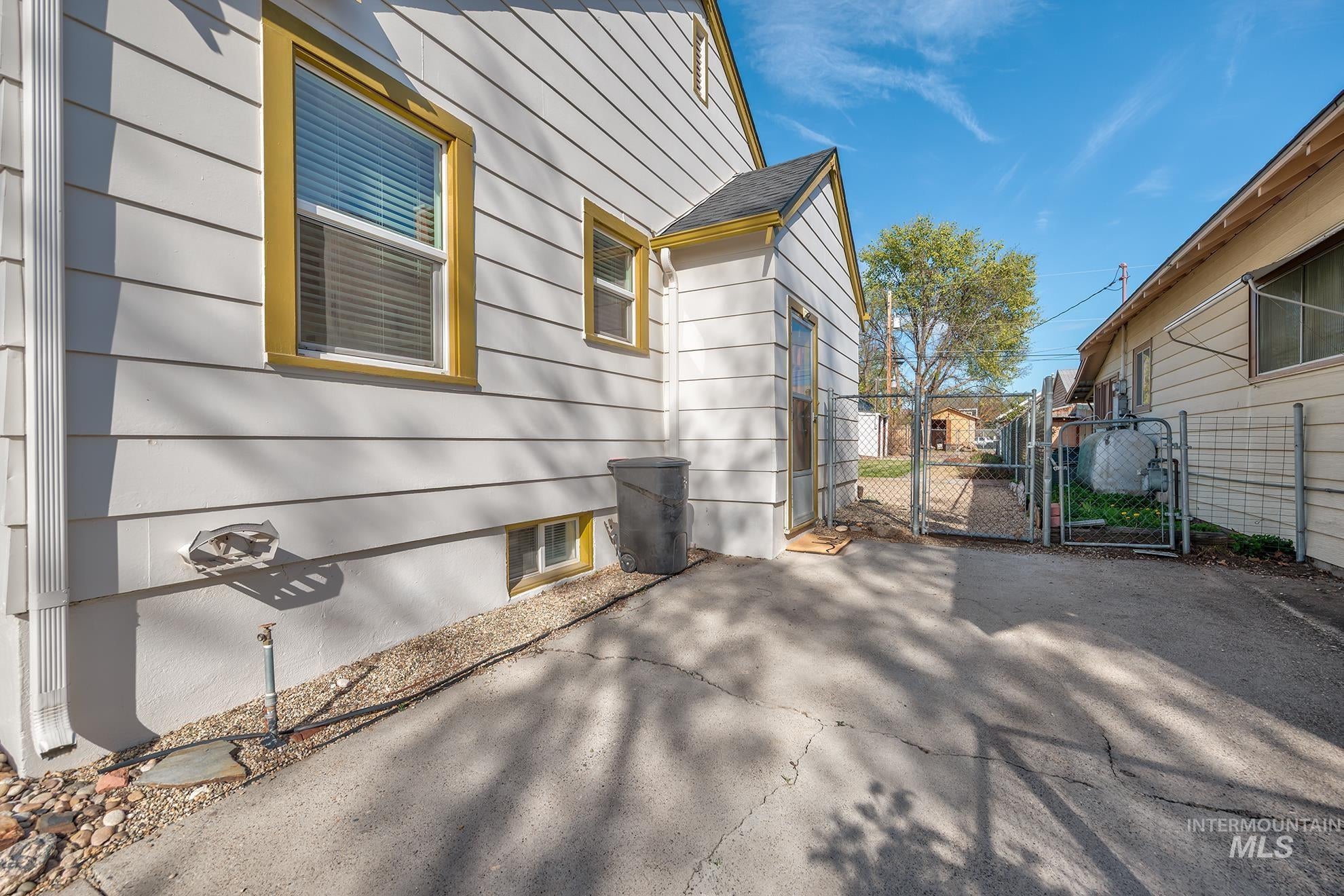 View of property exterior featuring a gate and a patio
