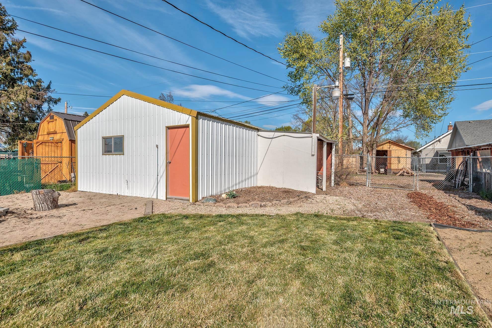 Fenced backyard featuring an outbuilding