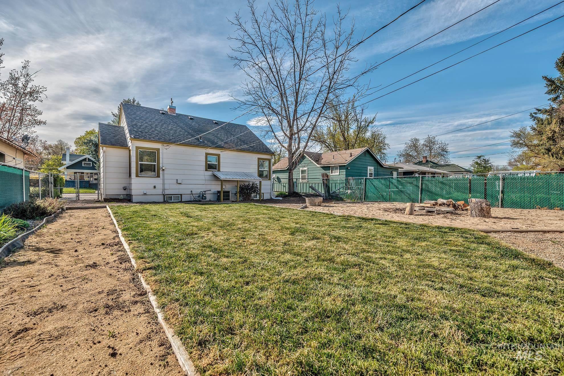 Rear view of property featuring a fenced backyard, a patio area, a shingled roof, and a chimney