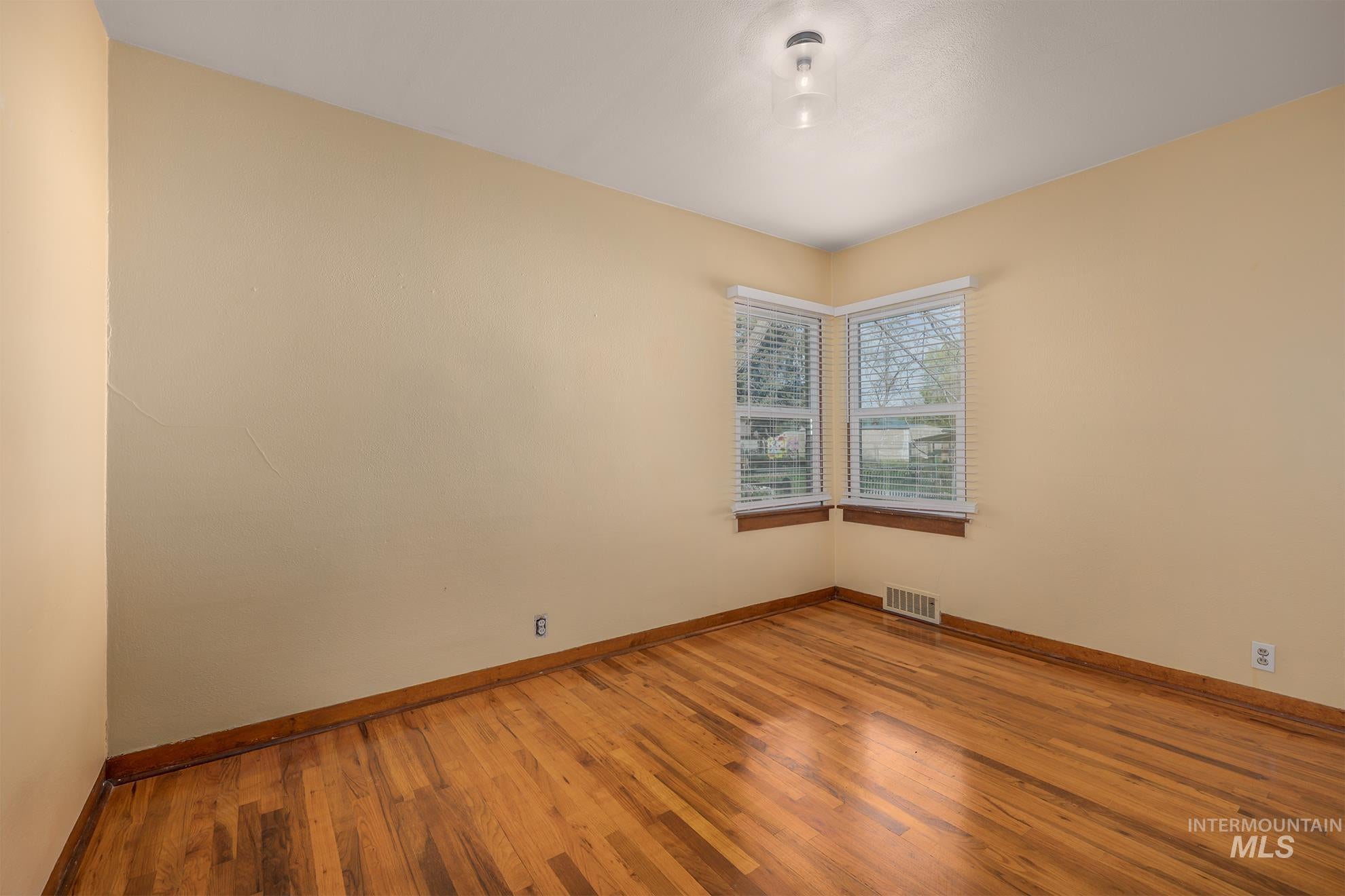 Empty room with baseboards and light wood-style floors