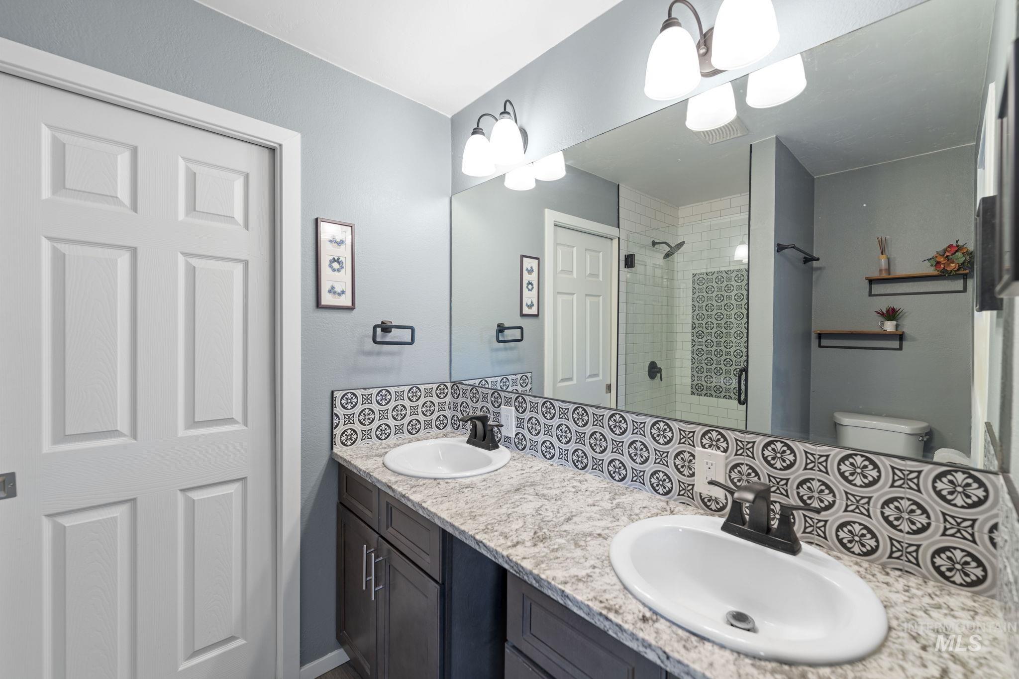 Full bath with a stall shower and double vanity