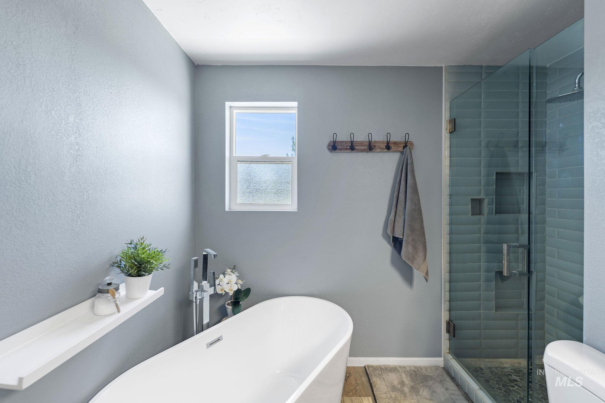 Full bath with a stall shower and a freestanding tub