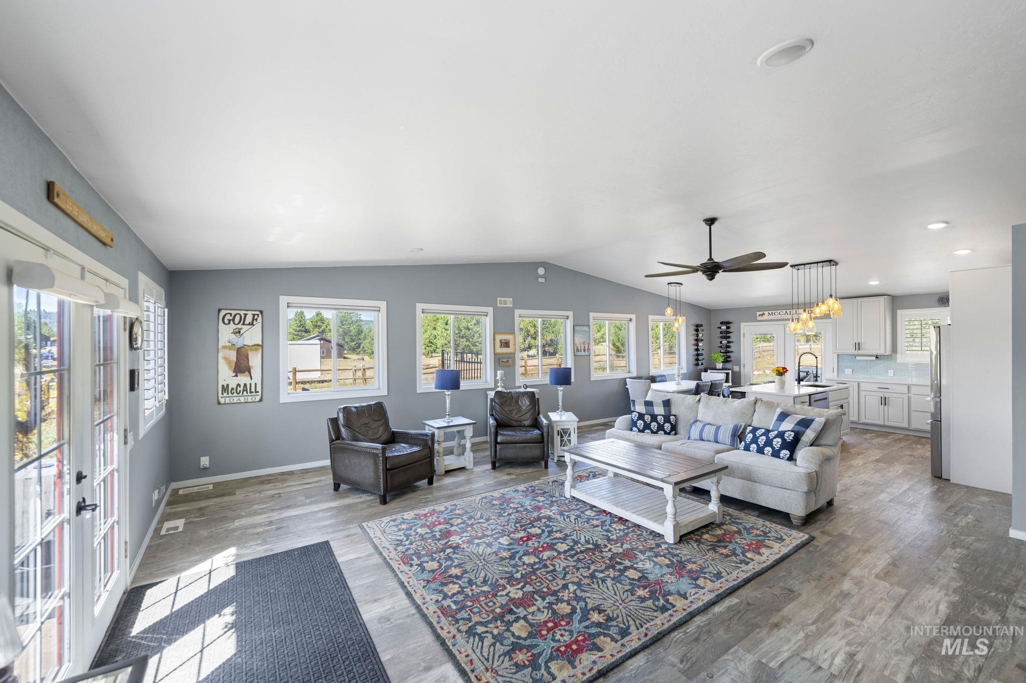 Living area featuring wood finished floors, a ceiling fan, and lofted ceiling