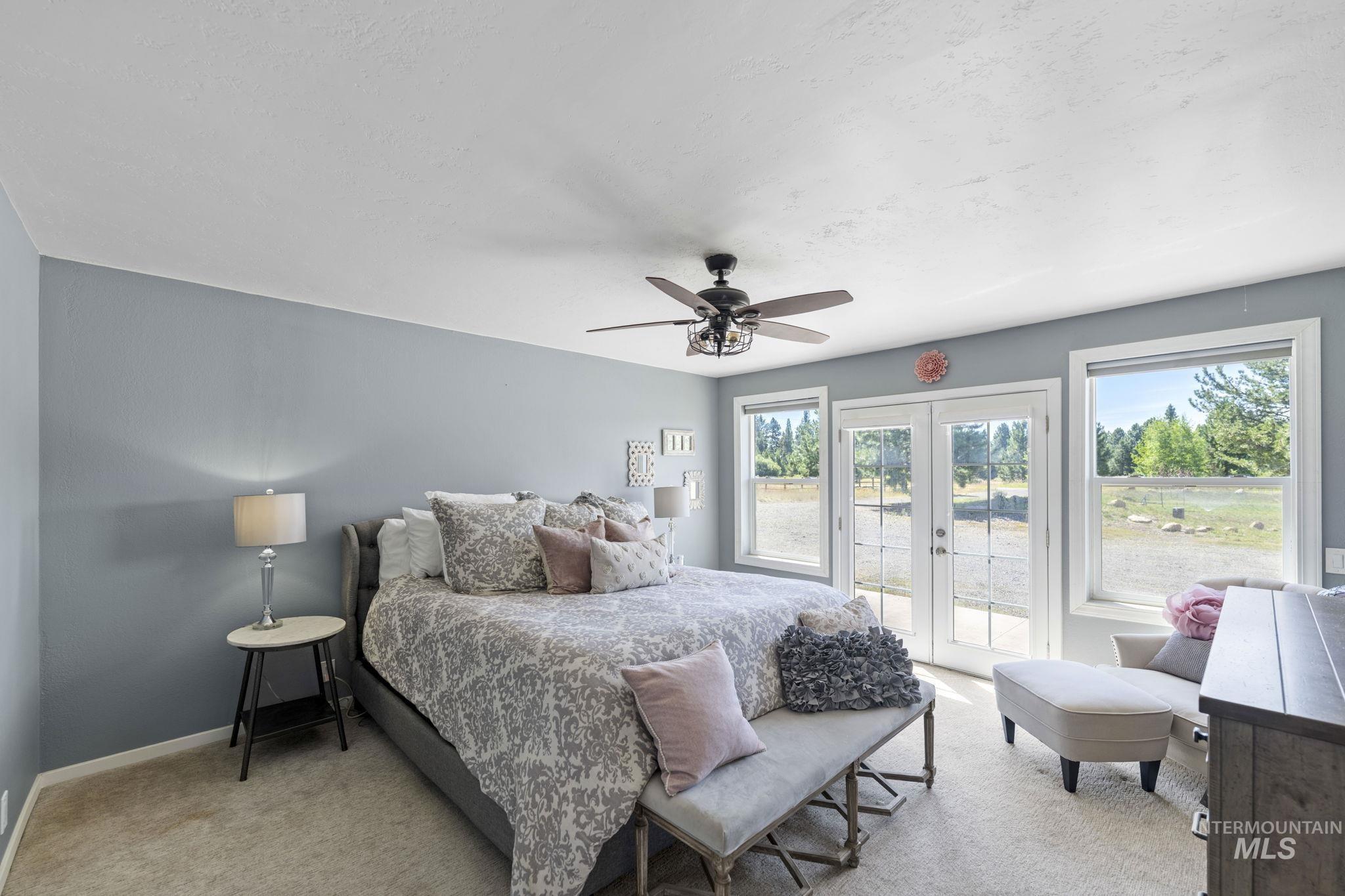 Bedroom with french doors, access to outside, light colored carpet, and a ceiling fan