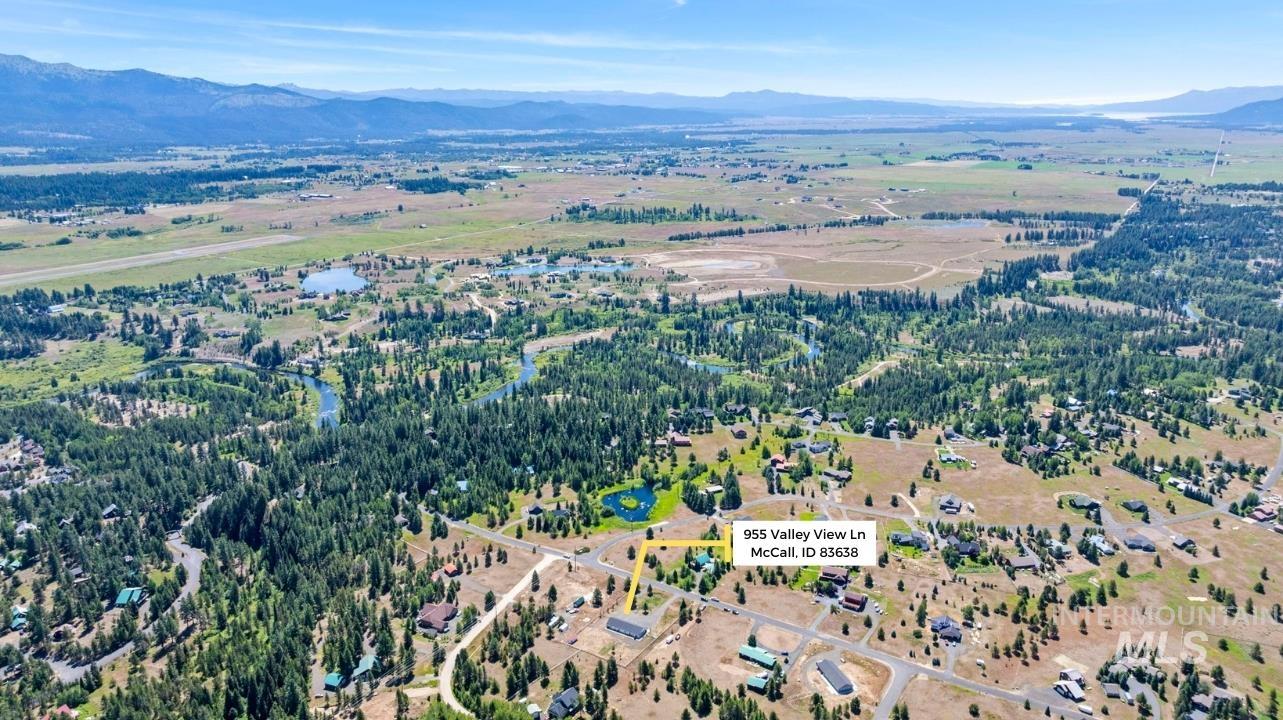 Aerial view of property and surrounding area with a mountainous background