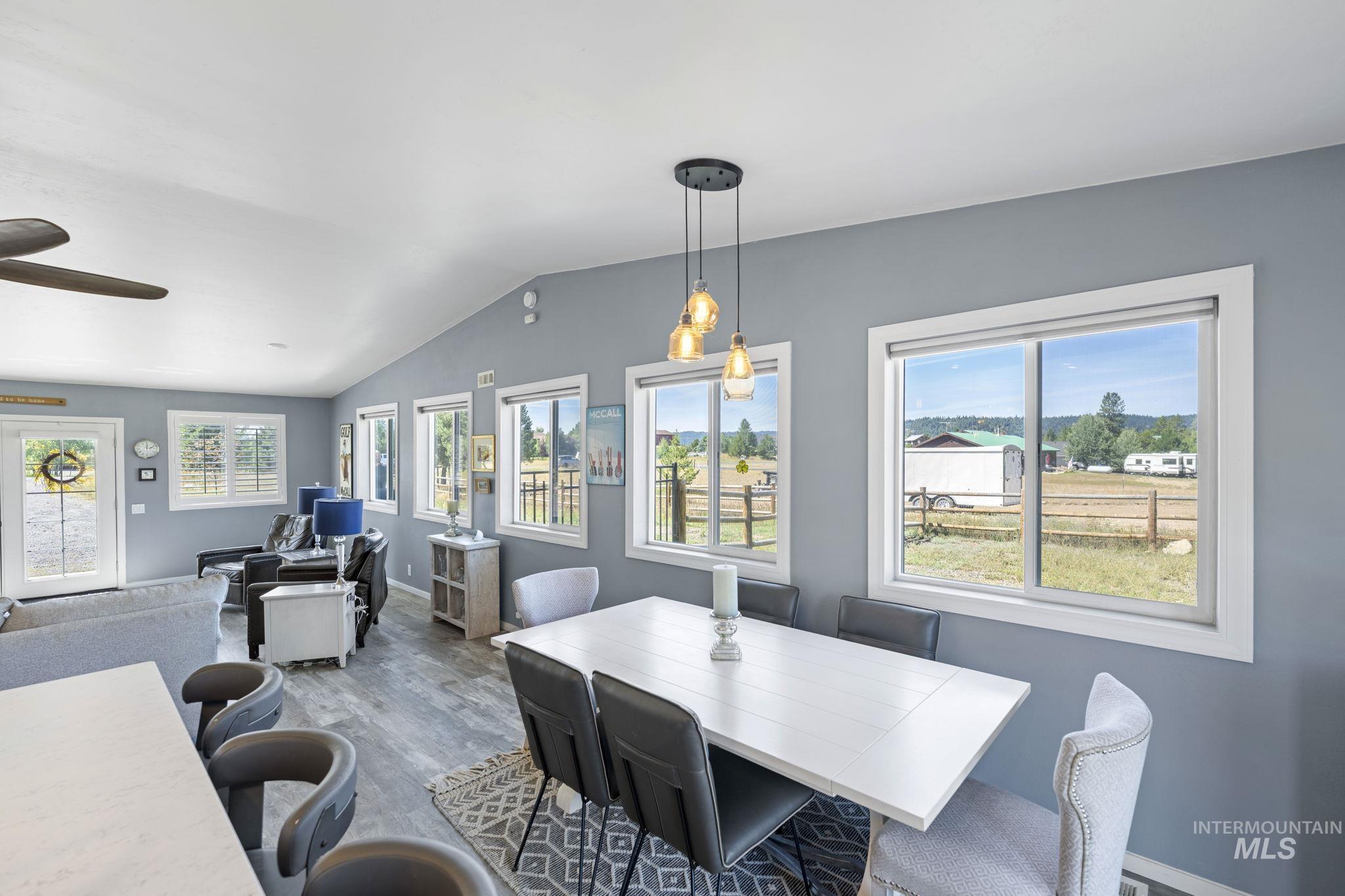 Dining area with wood finished floors, healthy amount of natural light, and vaulted ceiling