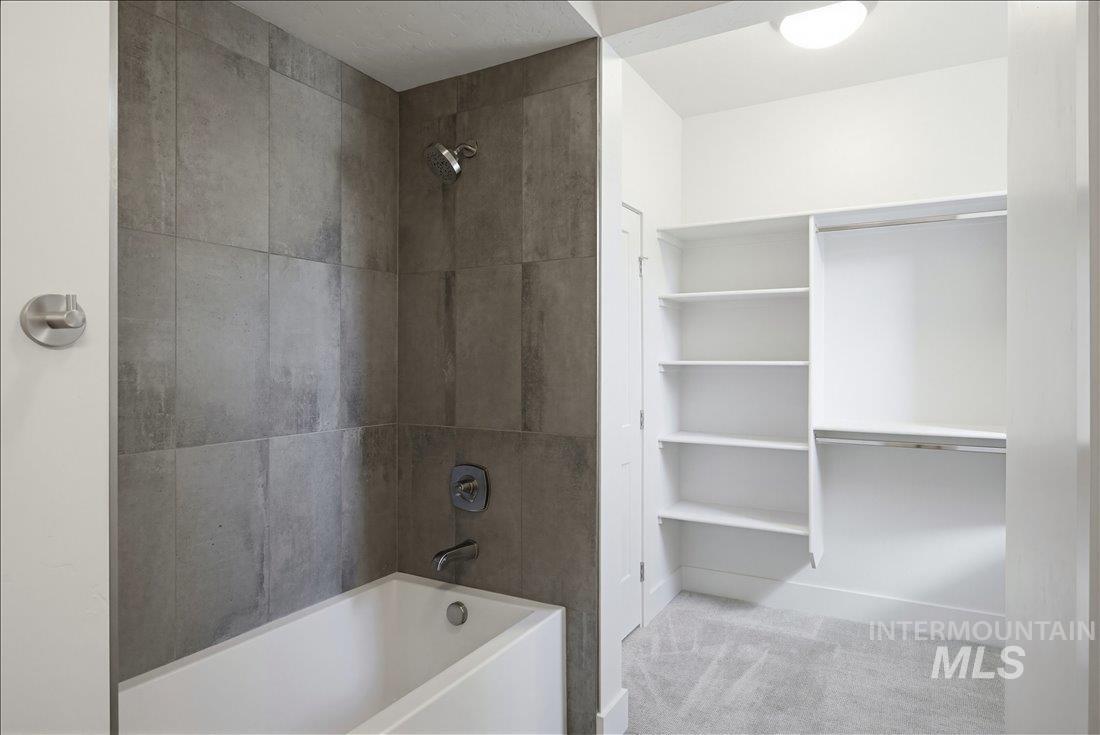 Modern bathroom featuring a deep soaking tub with brushed nickel fixtures and large format tile surround