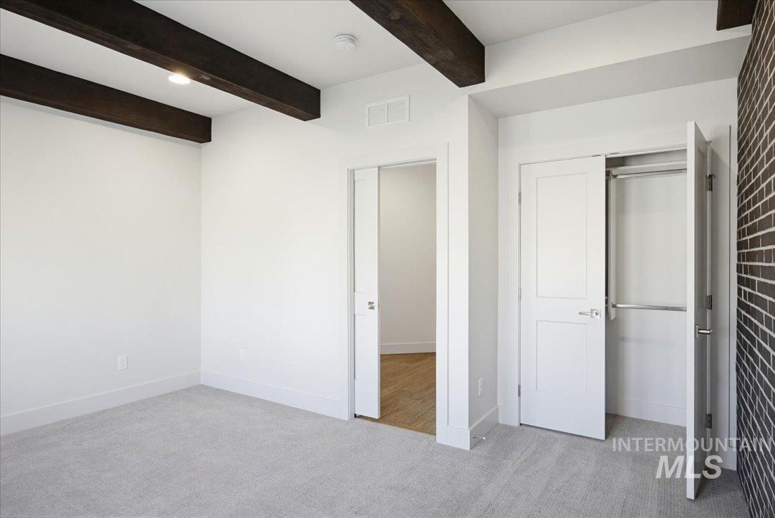 White walls with exposed dark wood ceiling beams