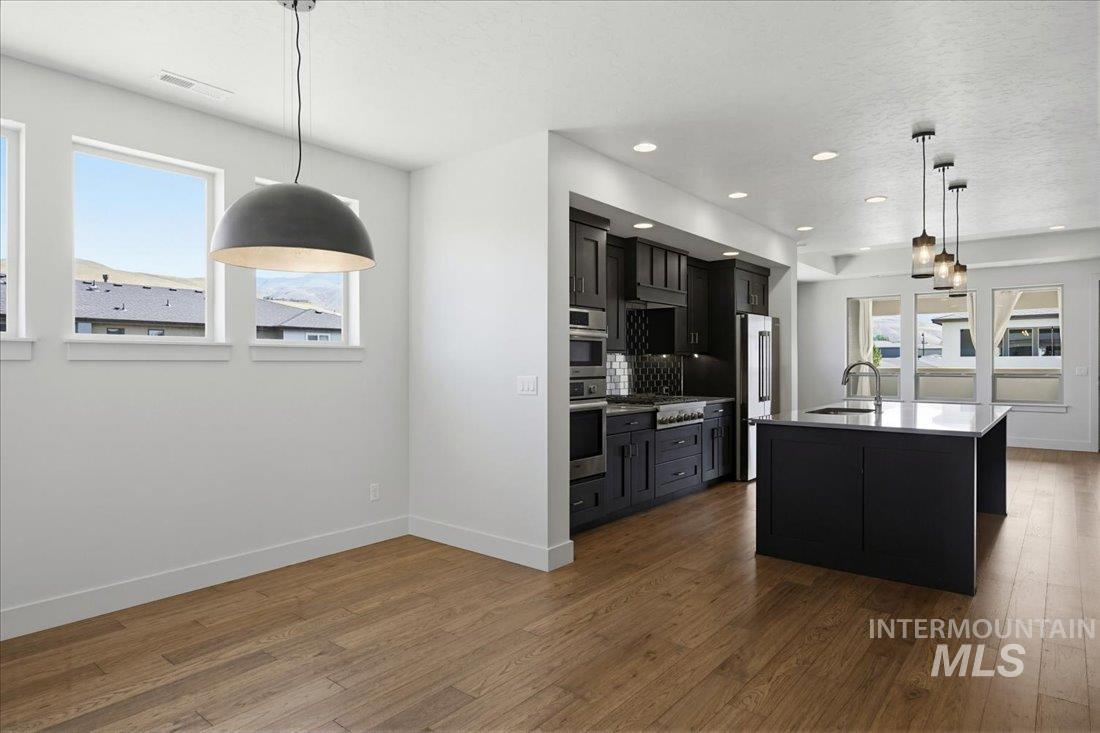 Open-concept living space featuring wood-finish flooring, recessed lighting, and a modern kitchen