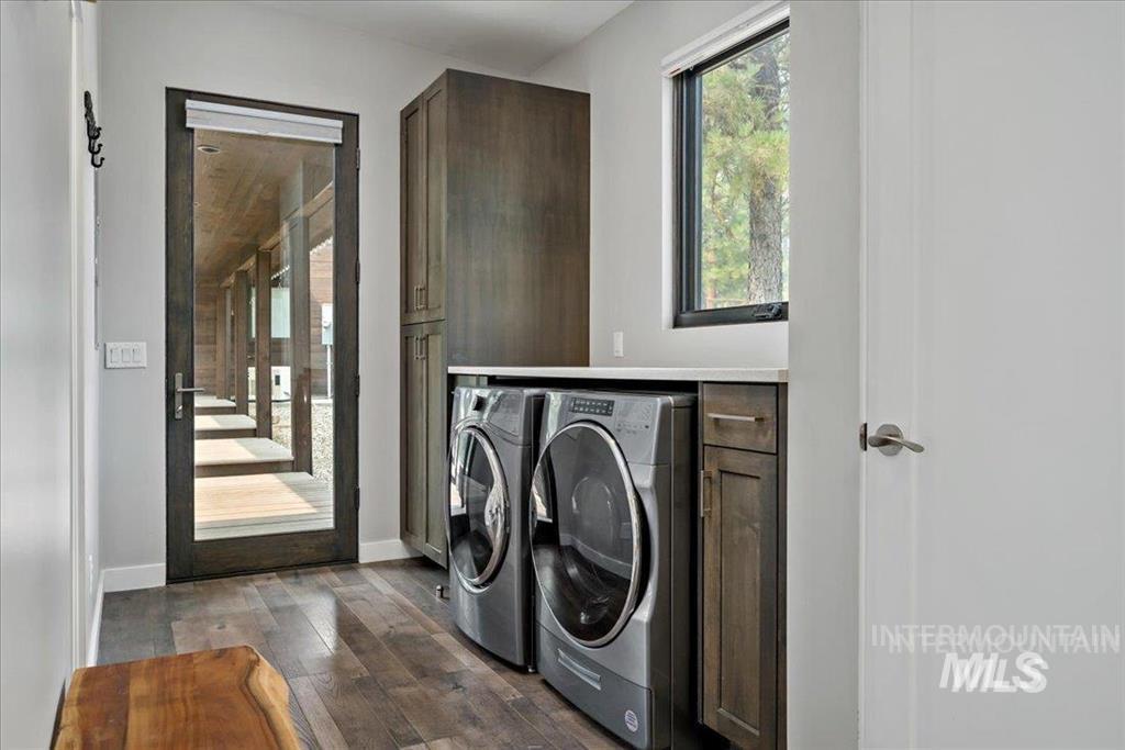 Laundry area featuring dark wood finished floors and washing machine and dryer
