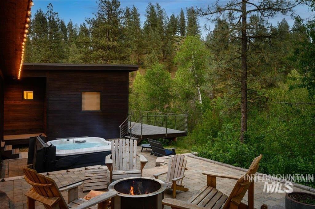 View of patio / terrace featuring a hot tub and an outdoor fire pit