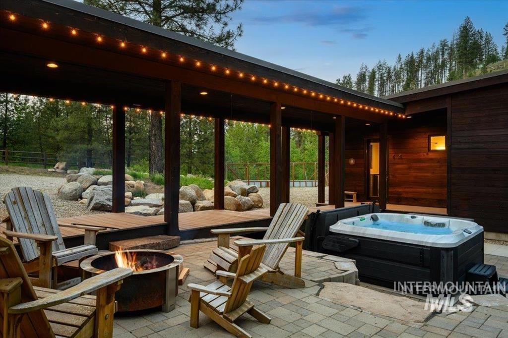View of patio featuring an outdoor fire pit and a hot tub