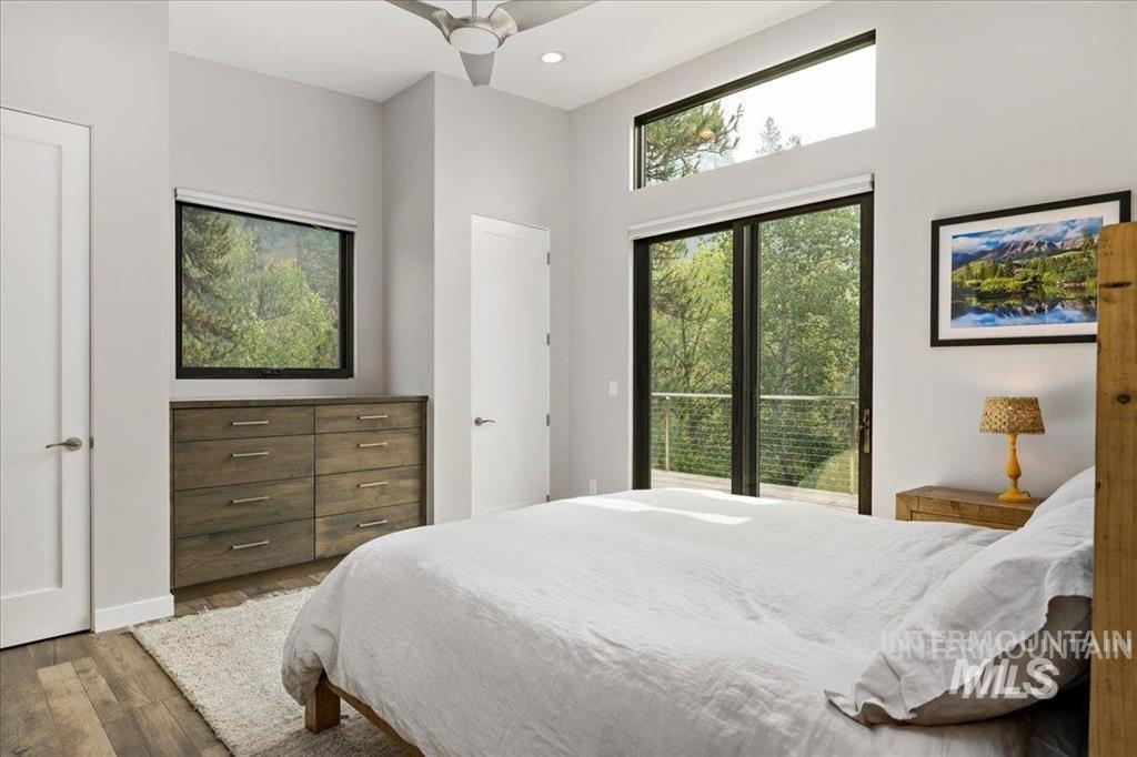 Bedroom with wood finished floors, recessed lighting, access to outside, and ceiling fan
