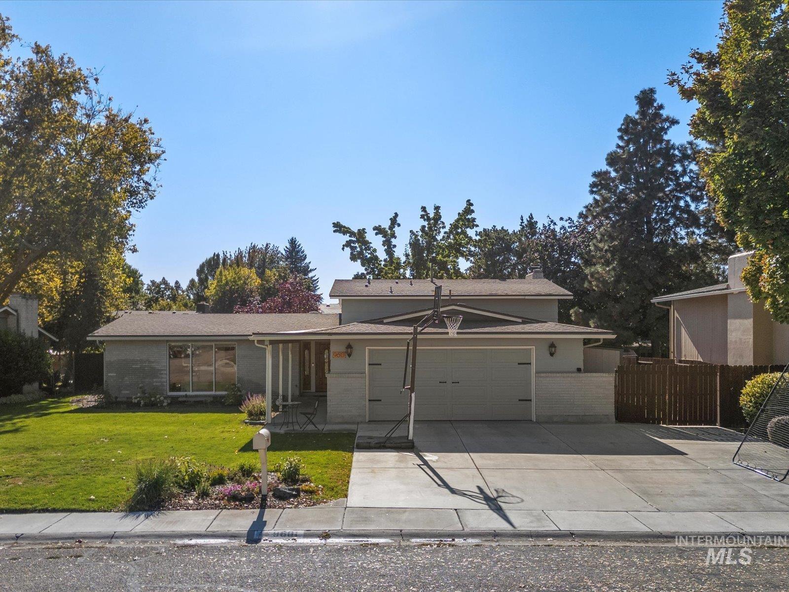 View of front of house featuring driveway, covered porch, an attached garage, and brick siding