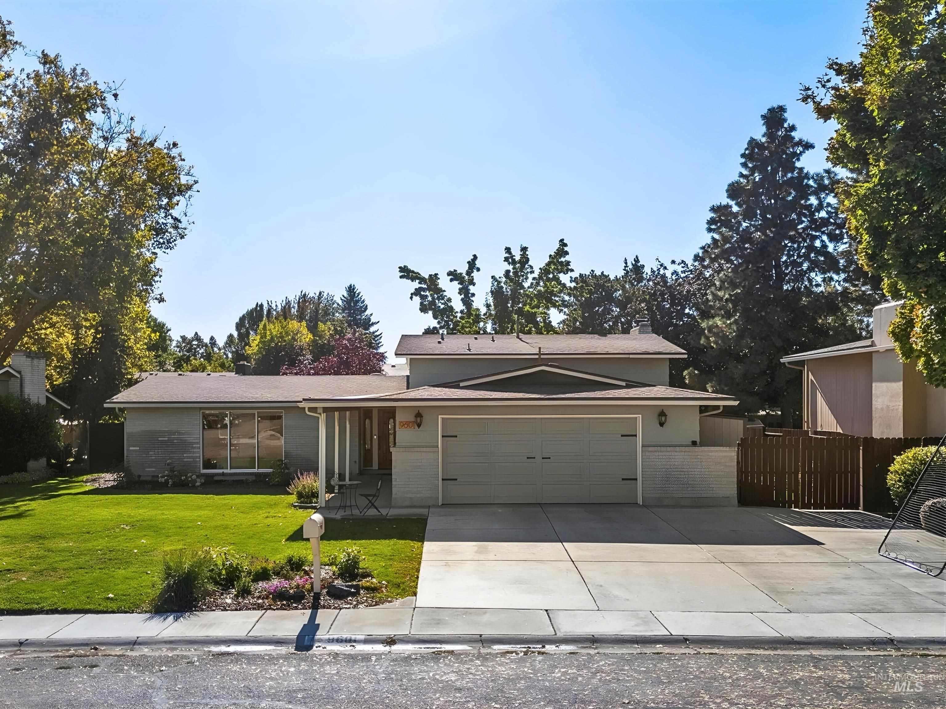 View of front of property with concrete driveway, brick siding, an attached garage, and covered porch