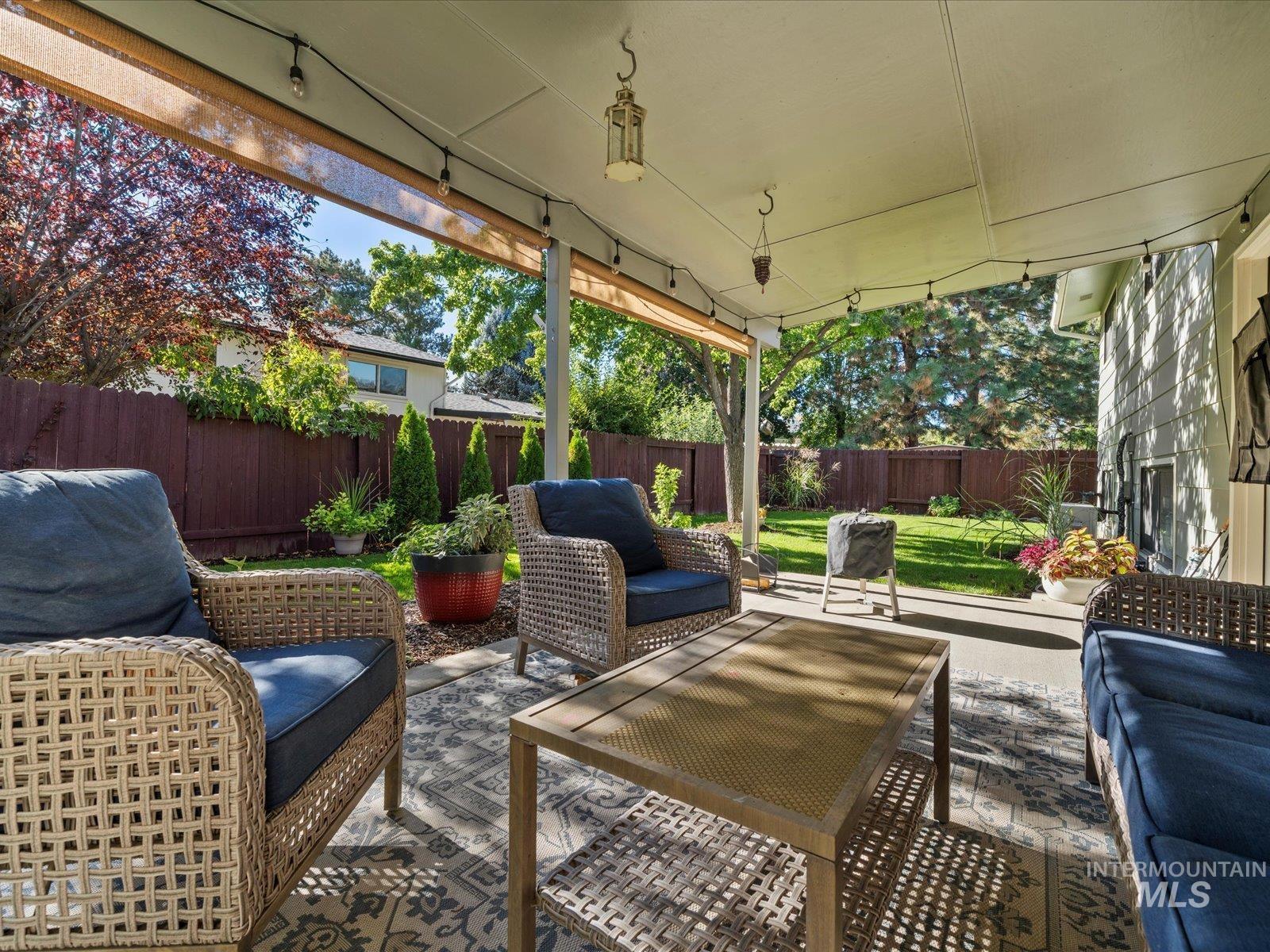 Fenced backyard with an outdoor living space and a patio area