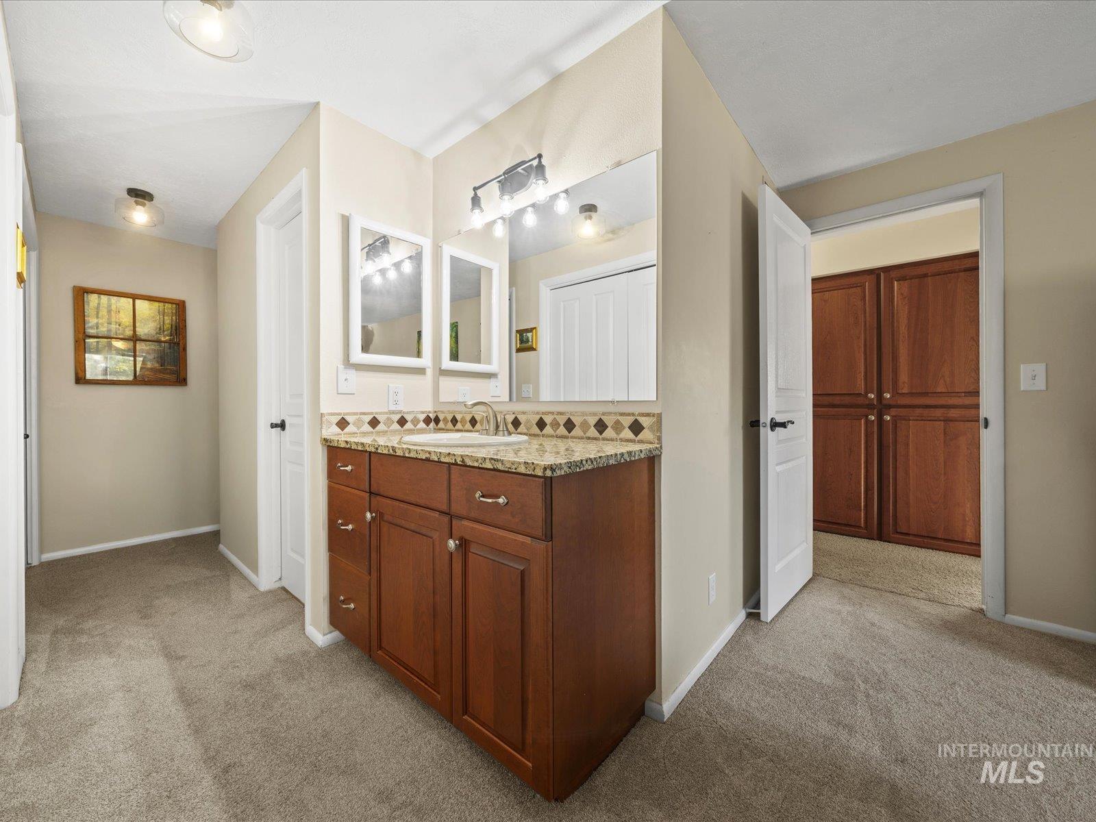 Bathroom featuring light colored carpet and vanity