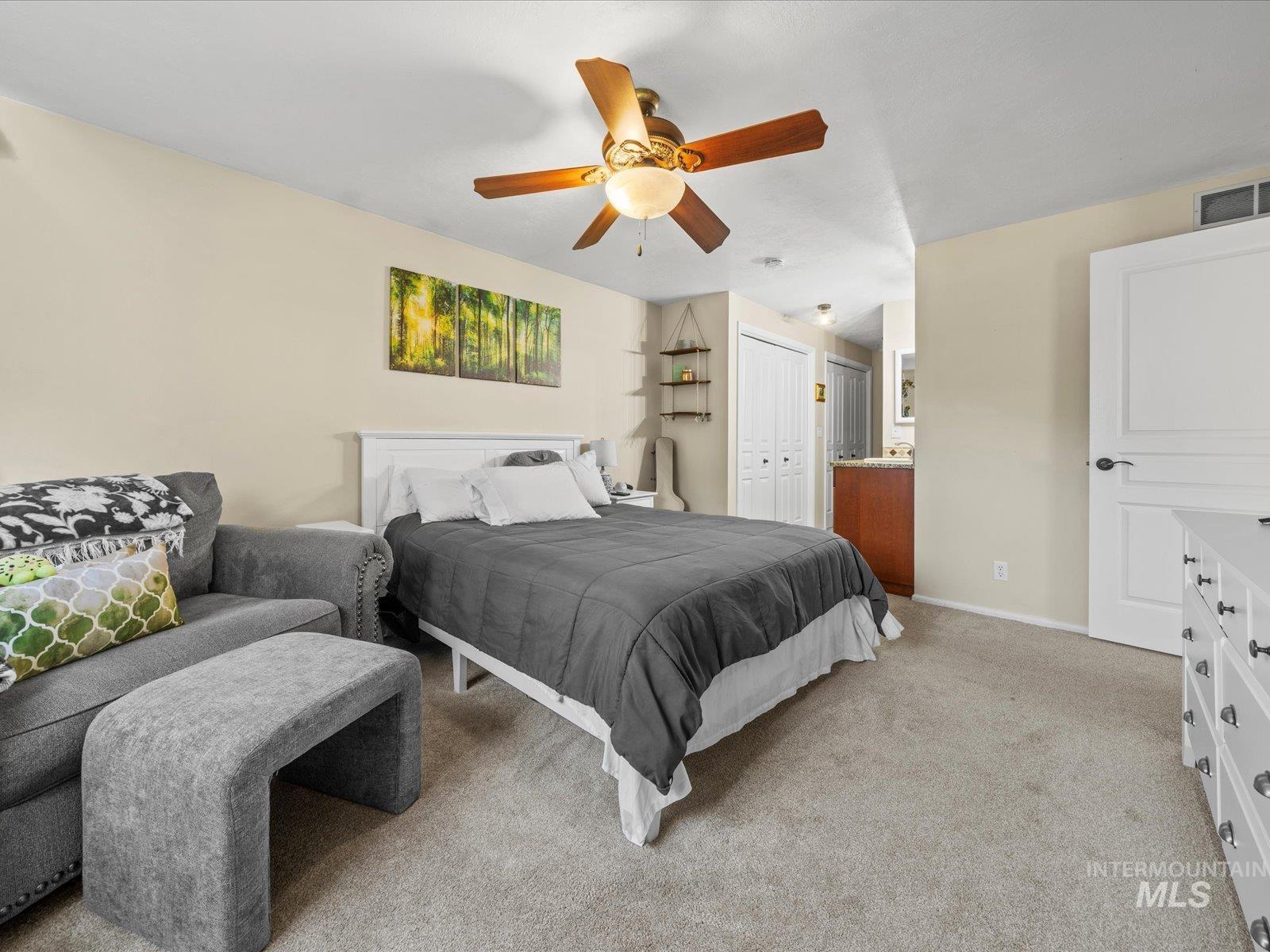 Bedroom with light colored carpet, a closet, and ceiling fan