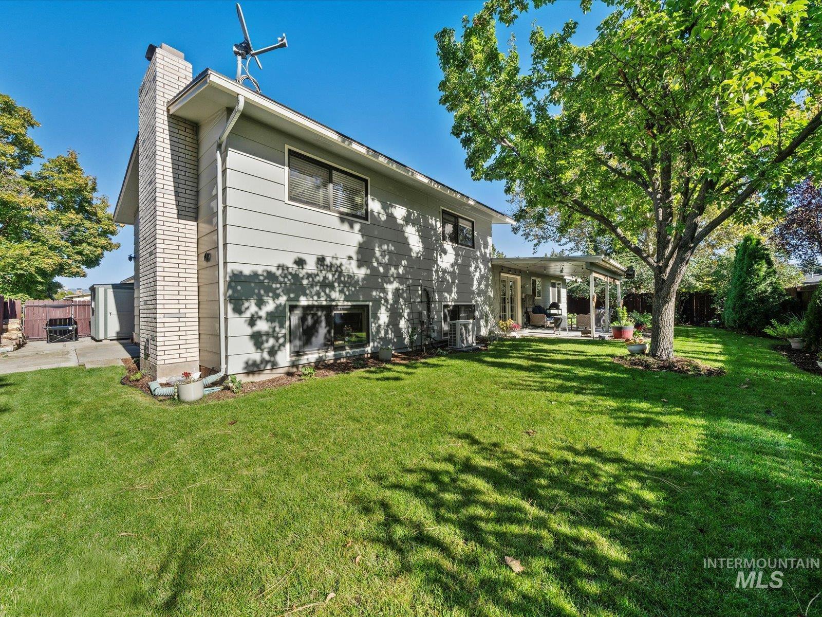 Rear view of property featuring a patio, a fenced backyard, and a chimney