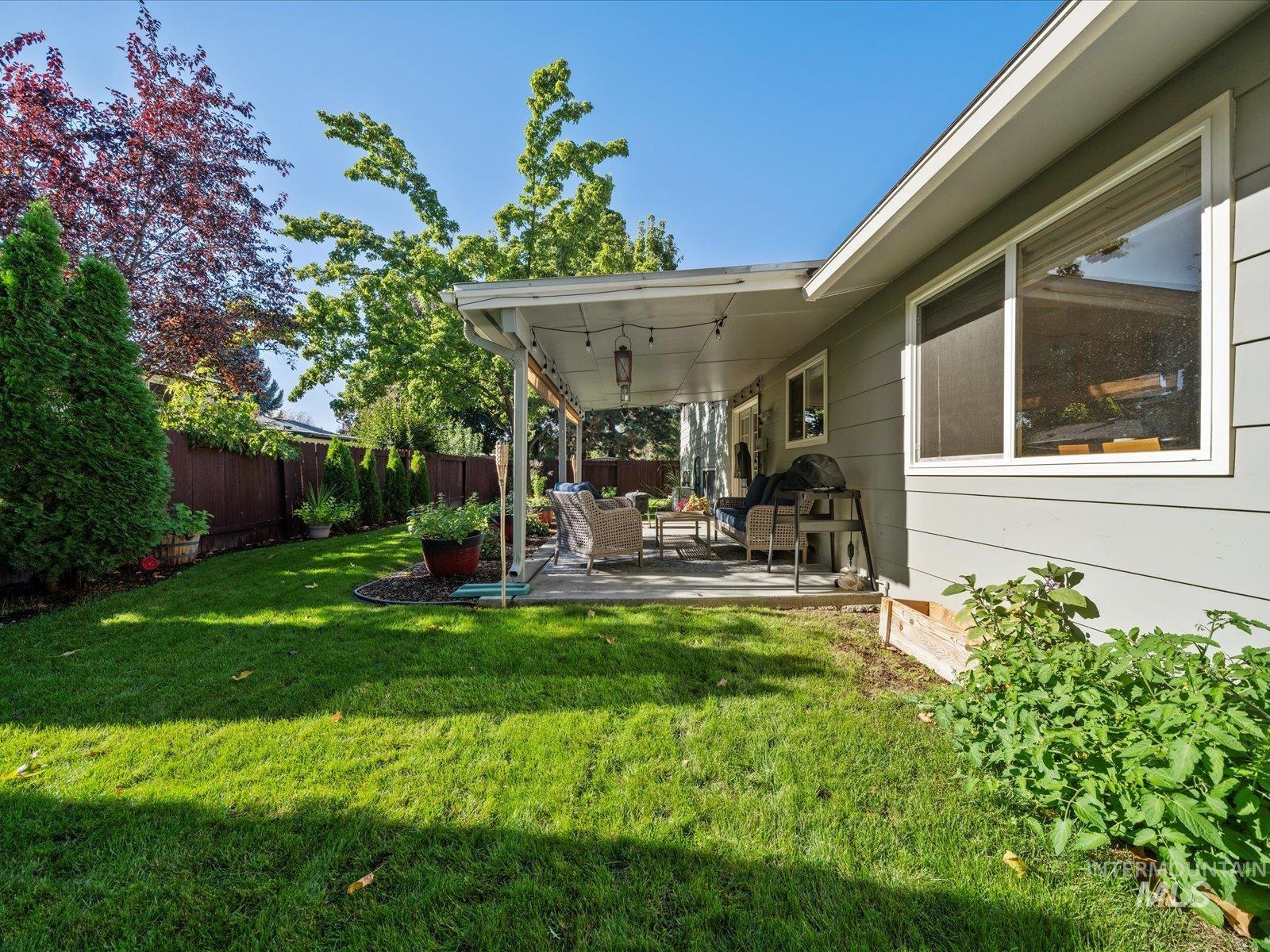Fenced backyard with a patio and outdoor lounge area