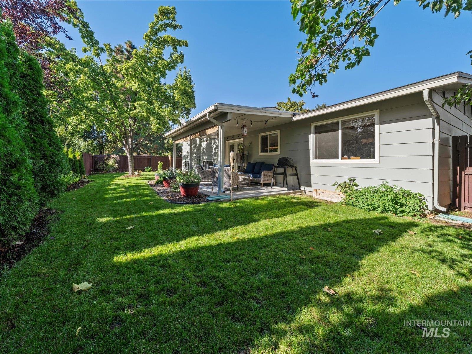 Rear view of property with a fenced backyard and a patio area