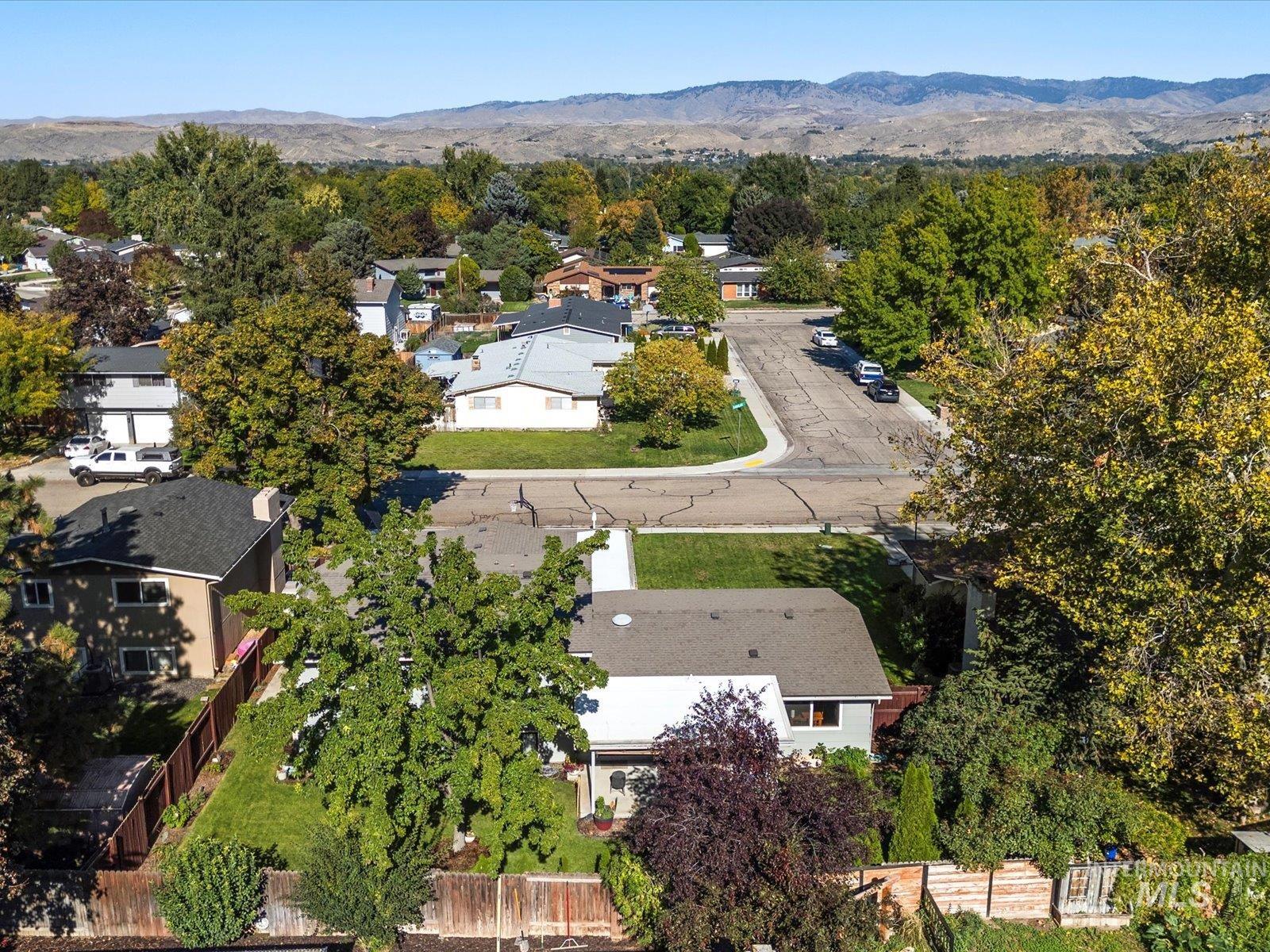 Aerial view of property and surrounding area with a mountain backdrop and nearby suburban area