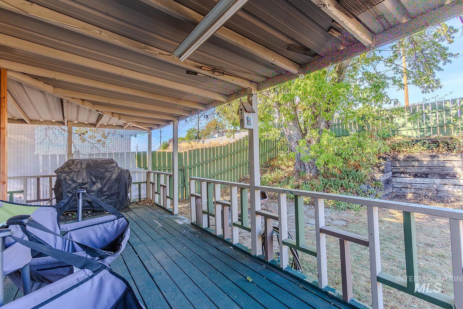 Wooden terrace featuring a grill and a fenced backyard