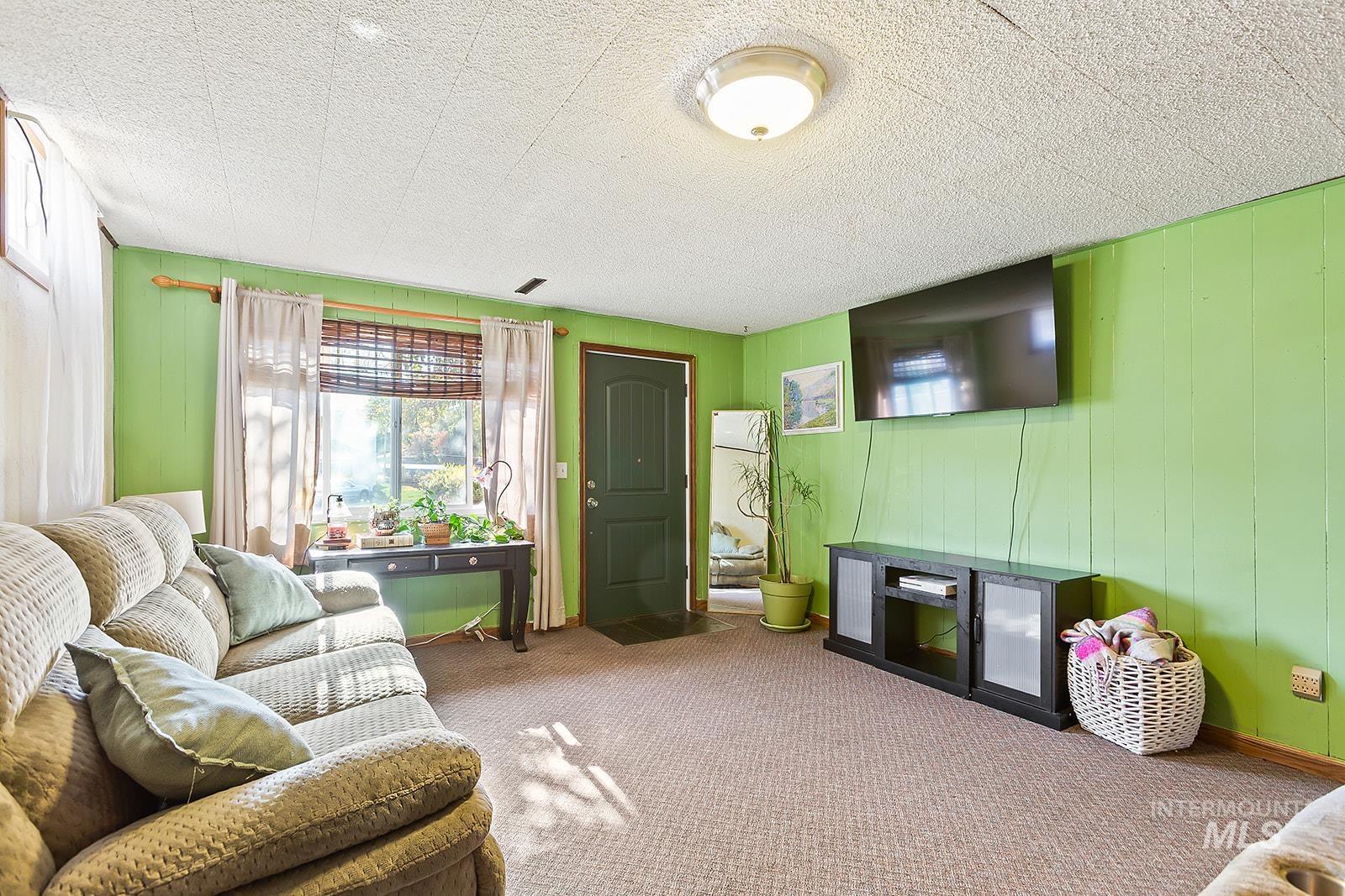 Living area with wooden walls and carpet floors