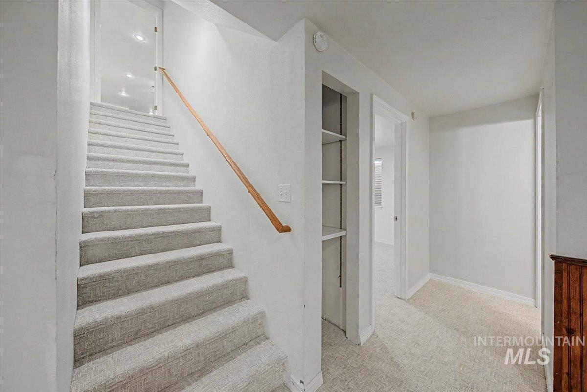 Stairway with carpet flooring and baseboards