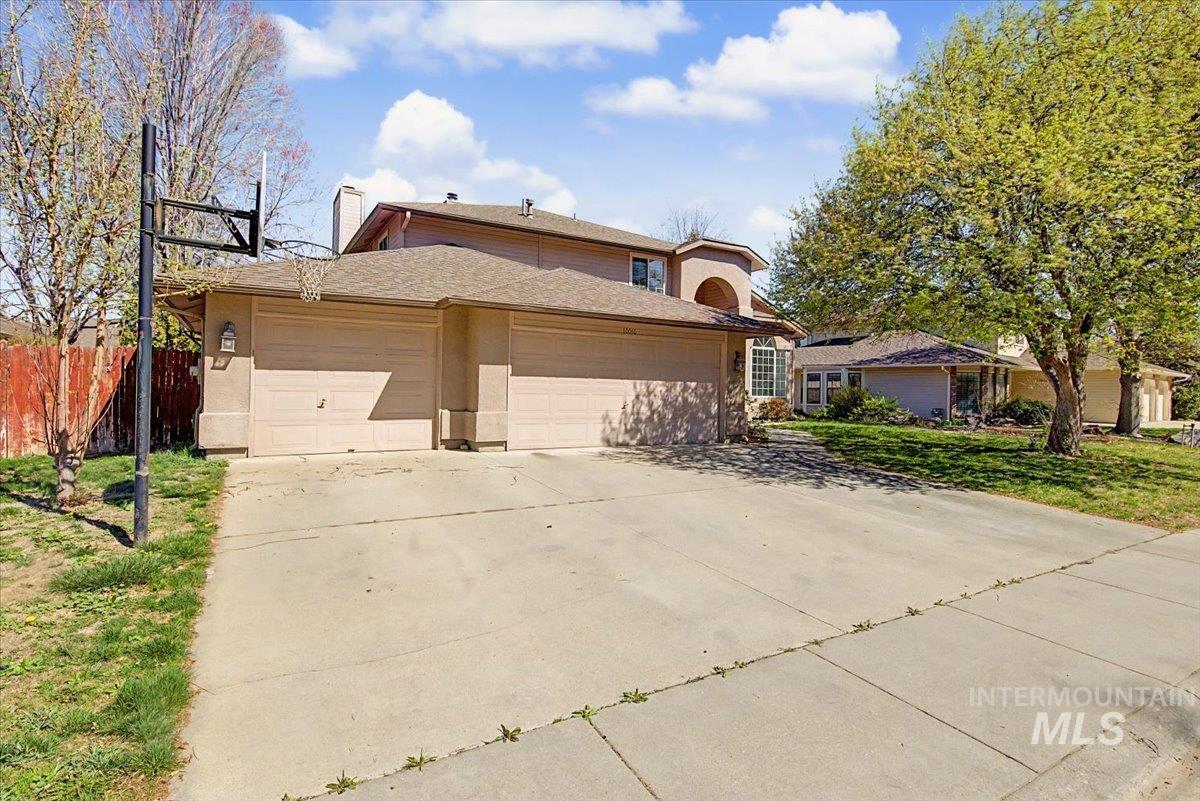 Traditional home featuring a garage, driveway, and a chimney
