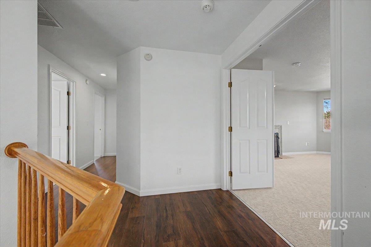 Corridor featuring wood finished floors and an upstairs landing