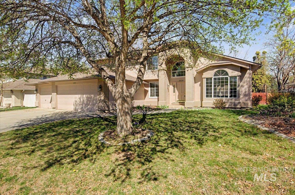 View of front of property with concrete driveway, a garage, and a front yard