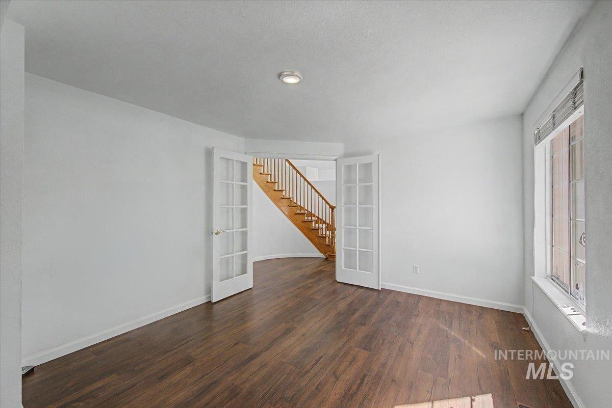 Empty room featuring french doors and dark wood-style floors