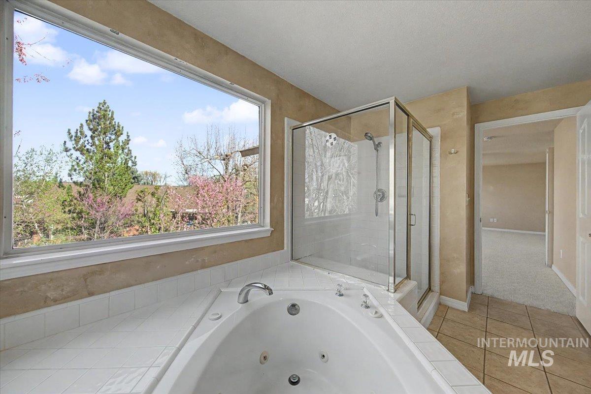 Full bathroom with a stall shower, a whirlpool tub, and light tile patterned floors