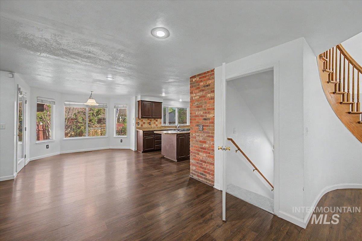 Unfurnished living room with dark wood-style floors and a textured ceiling