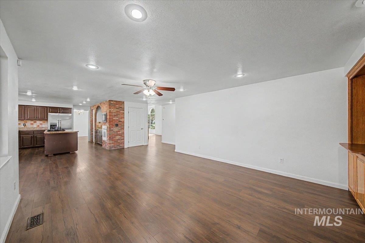 Unfurnished living room featuring recessed lighting, a textured ceiling, dark wood-style floors, and ceiling fan