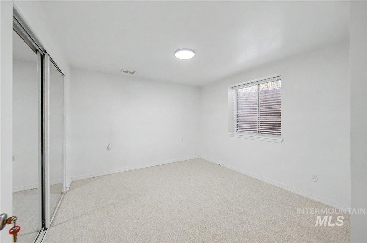 Unfurnished bedroom featuring a closet and light carpet