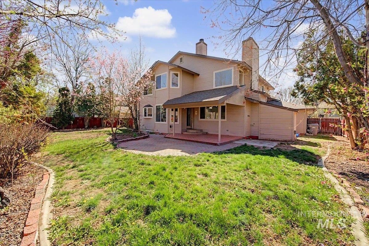 Rear view of property with a chimney, a fenced backyard, and a patio