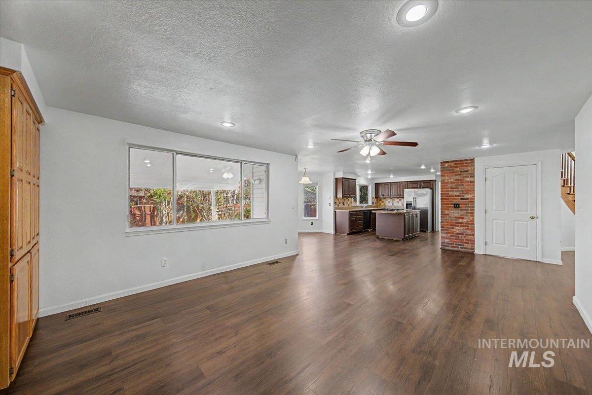 Unfurnished living room featuring ceiling fan, dark wood-style floors, a textured ceiling, and recessed lighting
