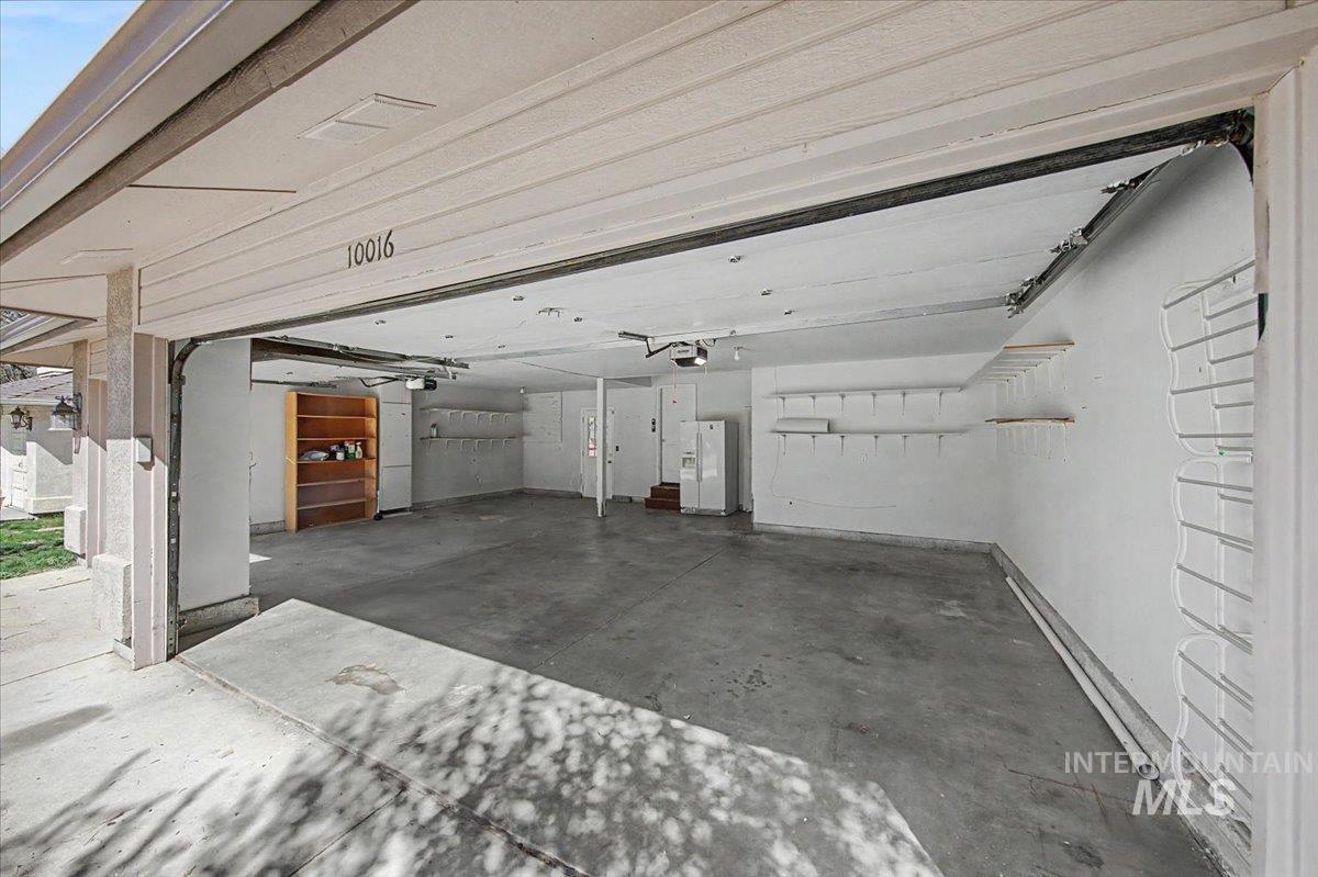 Garage featuring white fridge with ice dispenser