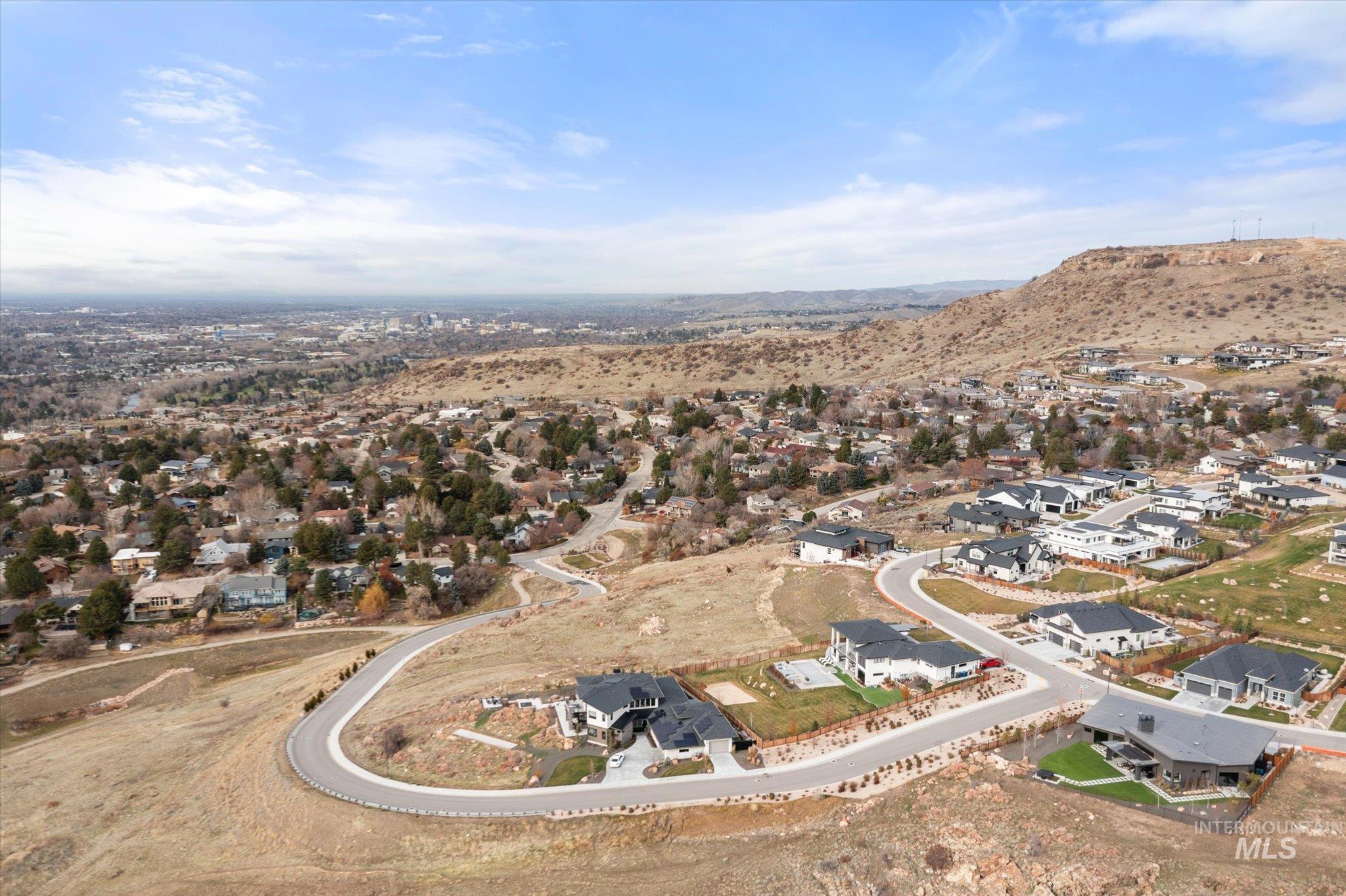 Aerial view of property and surrounding area featuring nearby suburban area