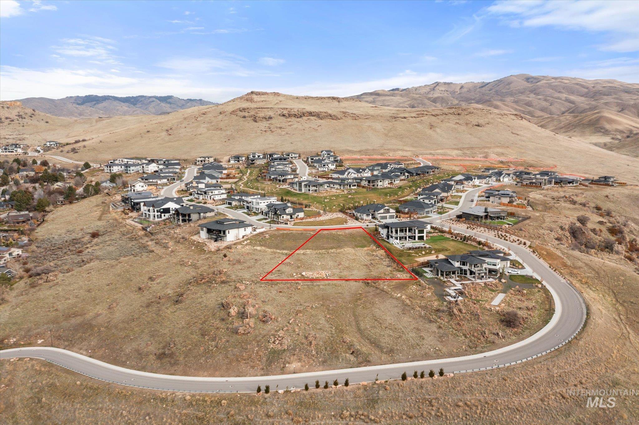 Aerial perspective of suburban area with a mountainous background and property parcel outlined