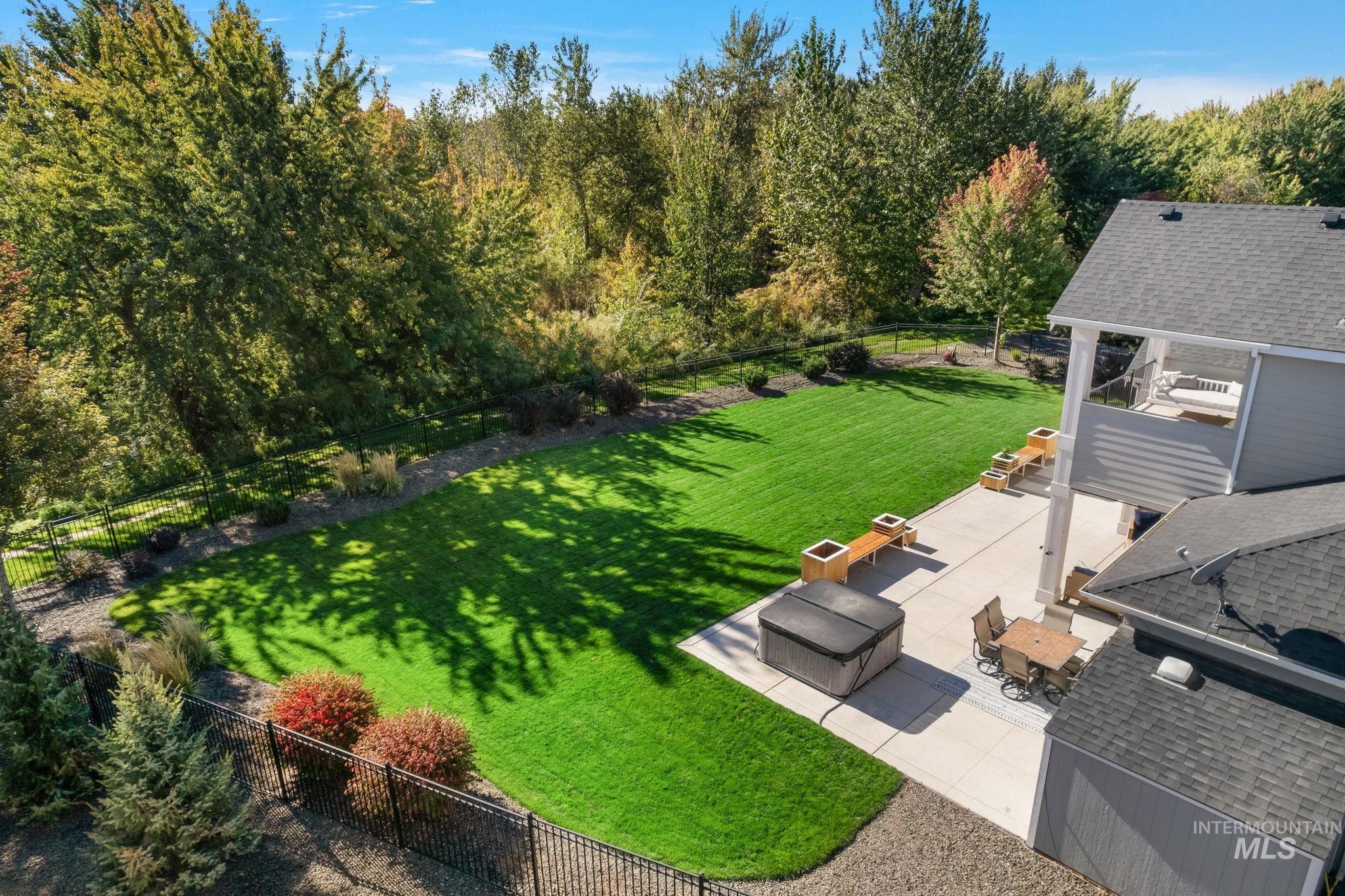 Fenced backyard with a patio area, outdoor dining area, a view of river & trees